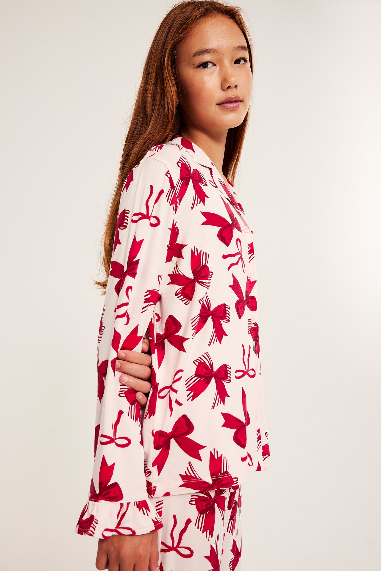 Mönstrad långärmad kvinnlig pyjamas i trikå med rosa bows och ränder.