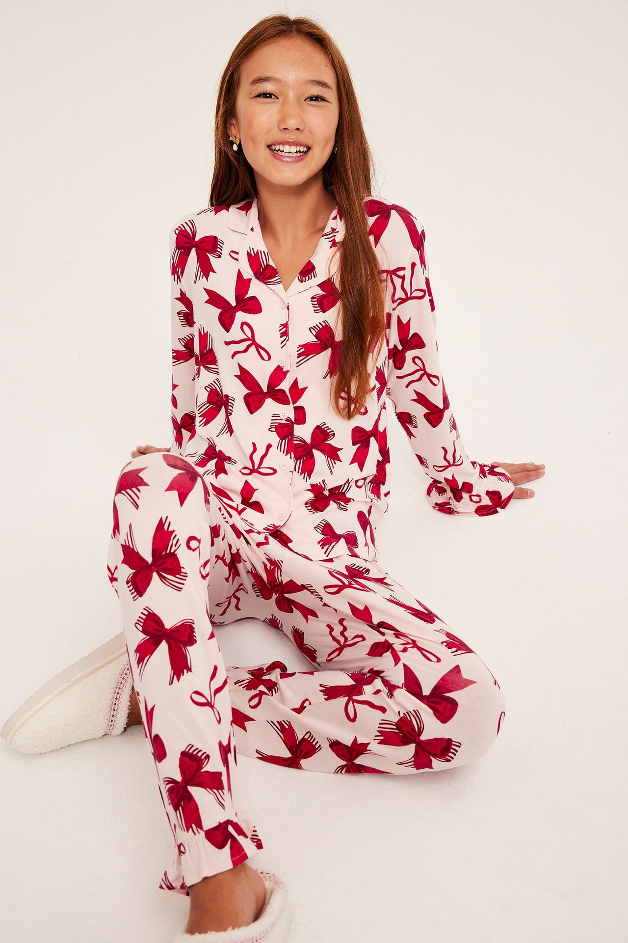 Pitkähihaista vaaleanpunaista haalaria punaisilla rusetti-kuvioilla, trikoo pidempiin öihin.