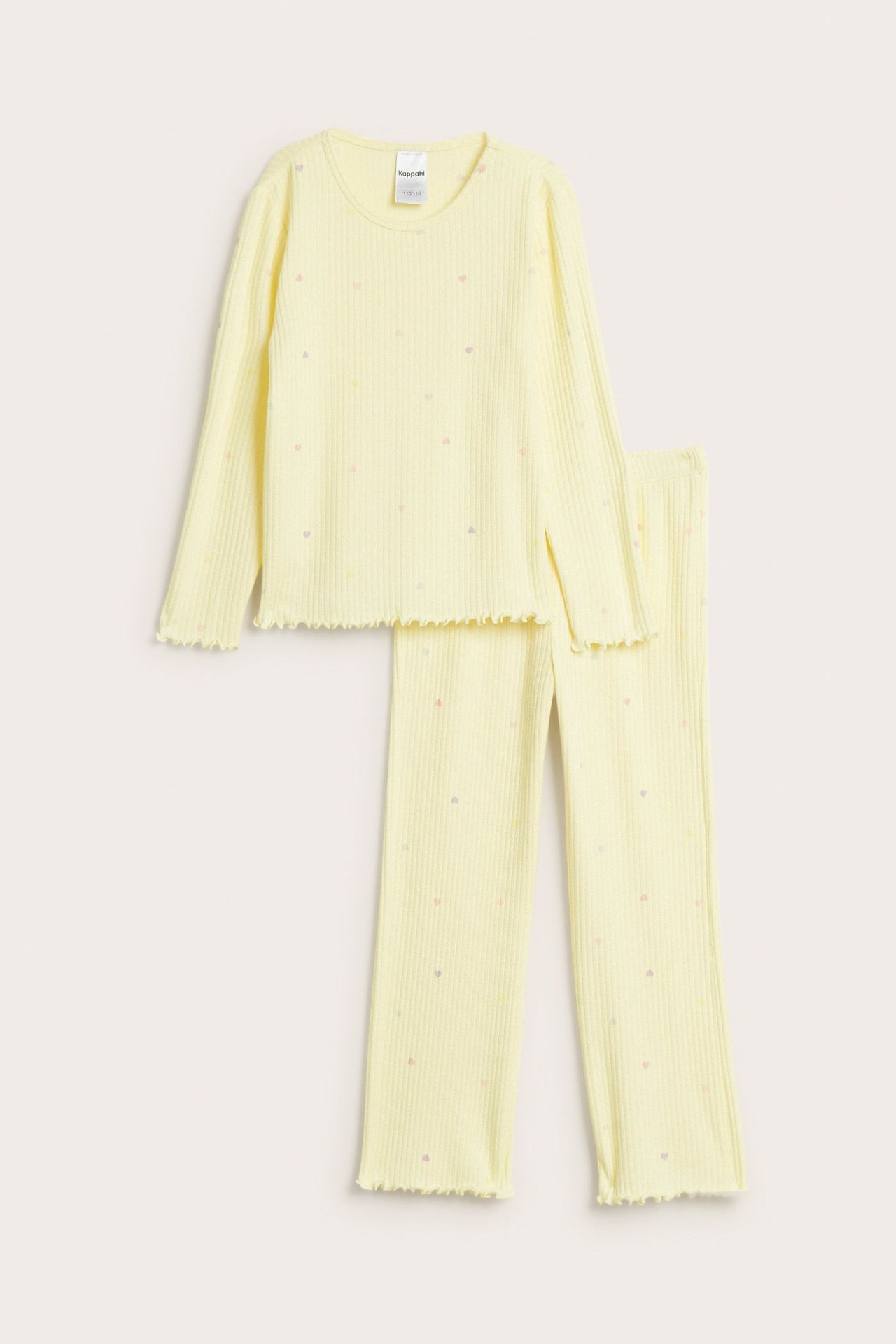 Framsida av ljusgul ribbad pyjamas för barn med små hjärtan och volangkanter.