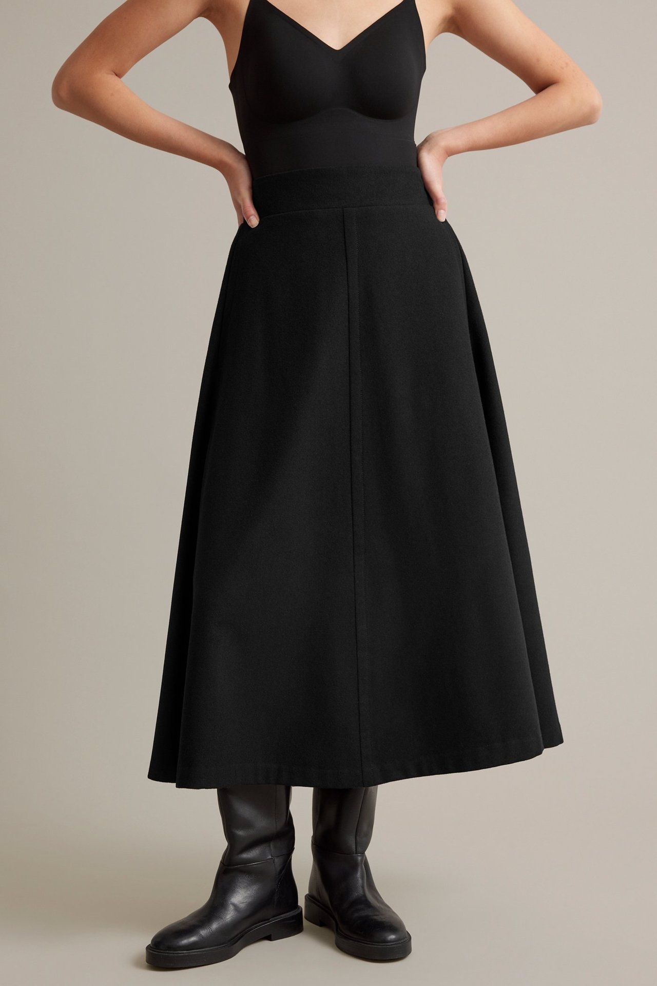 Musta A-linjainen villasekoitekielto sivutaskuilla ja joustavalla vyötäröllä.