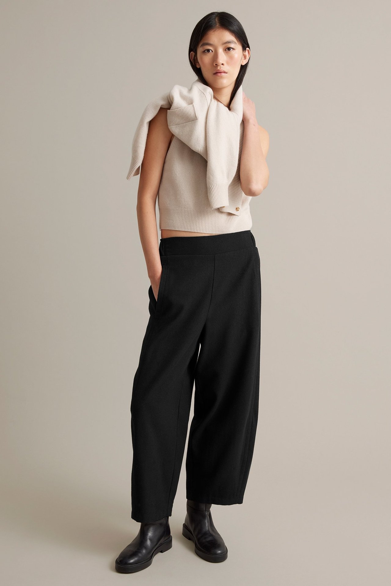 Nainen käyttää mustia mellitekniä villasekoitusfarkkuja sivu- ja takataskuilla, joustava vyötärö.