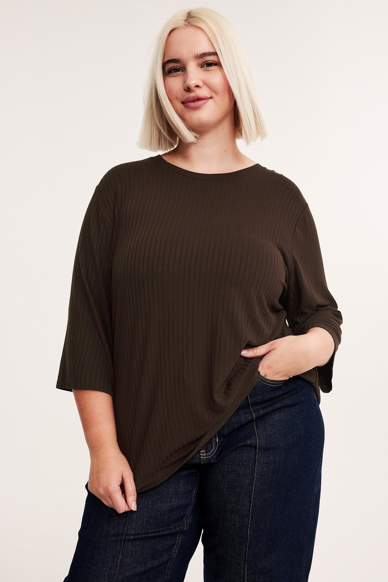 Widok z przodu: kobieta w ciemnobrązowym prążkowanym topie wiskozowym 3/4 i ciemnoniebieskich dżinsach.