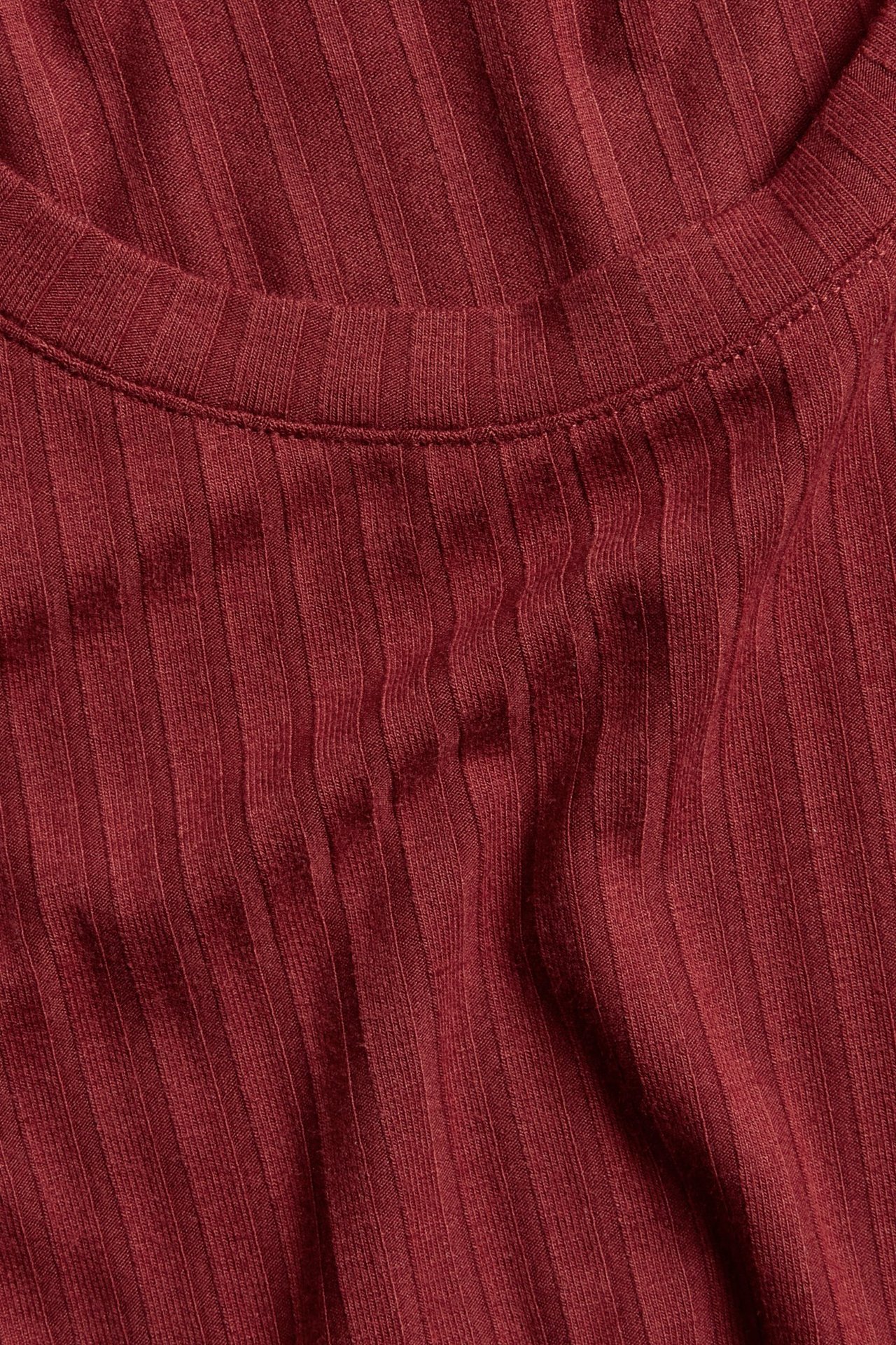 Zbliżenie czerwonej, prążkowanej koszulki z mieszanki wiskozy z okrągłym dekoltem.