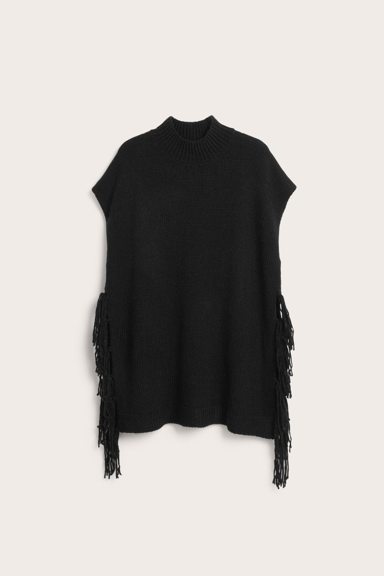 Framifrån: Lång svart stickad väst med hög hals och fransar på sidorna.