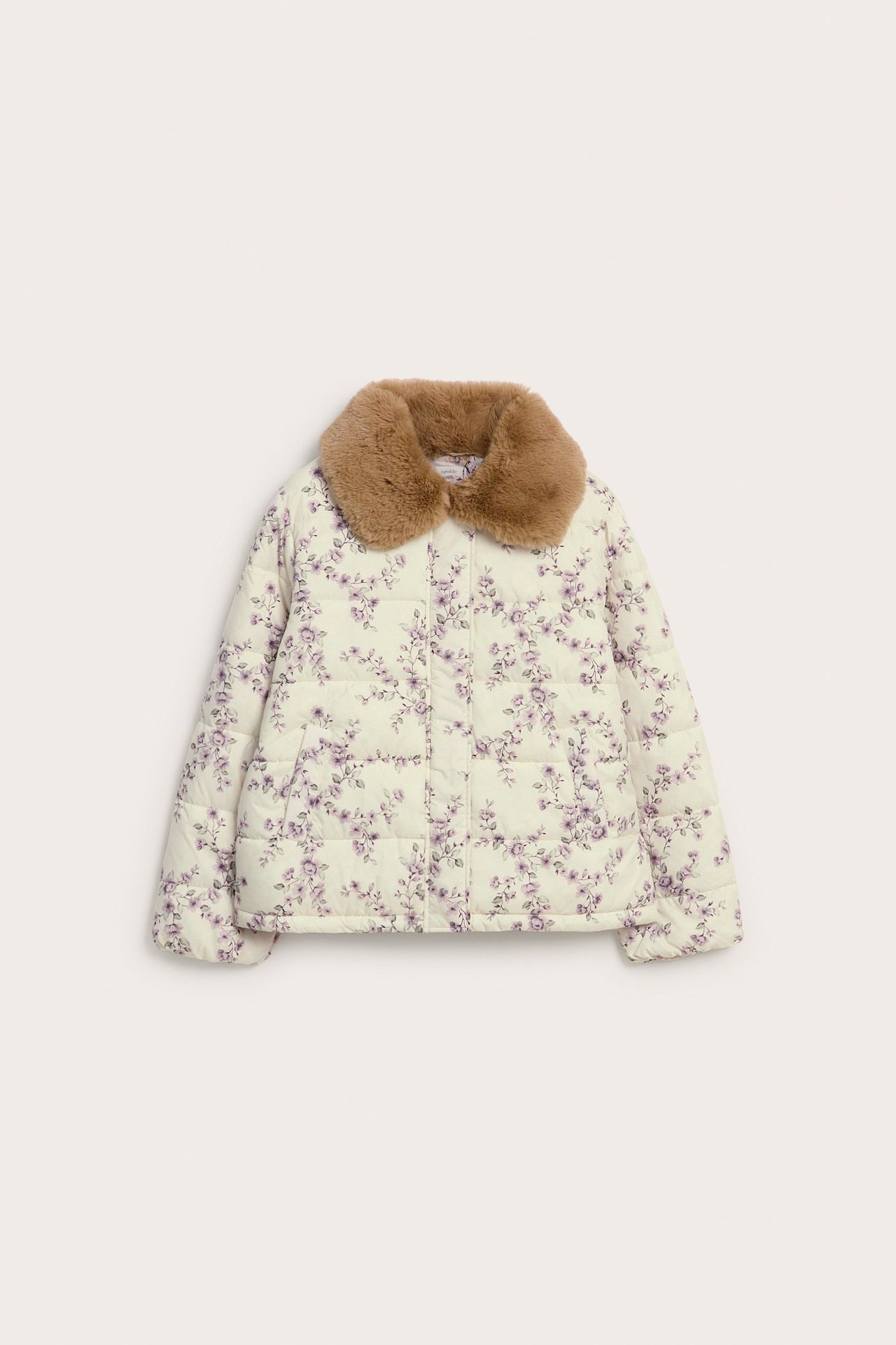 Frontvy: Kvinnas ljusbeige blommiga vadderade jacka med brun fuskpälskrage.