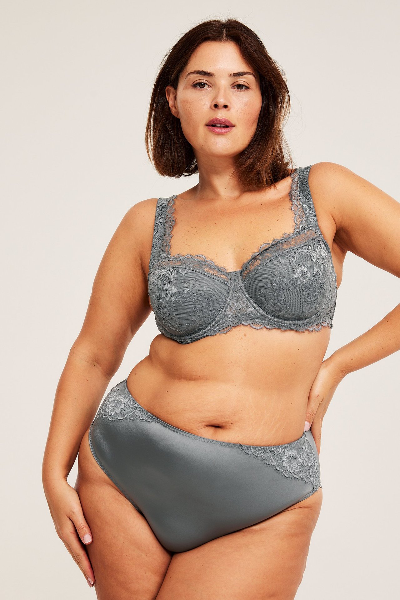 Framifrån, kvinna i grå spets-balconette-bh med vadderade kupor och matchande satinunderbyxor.