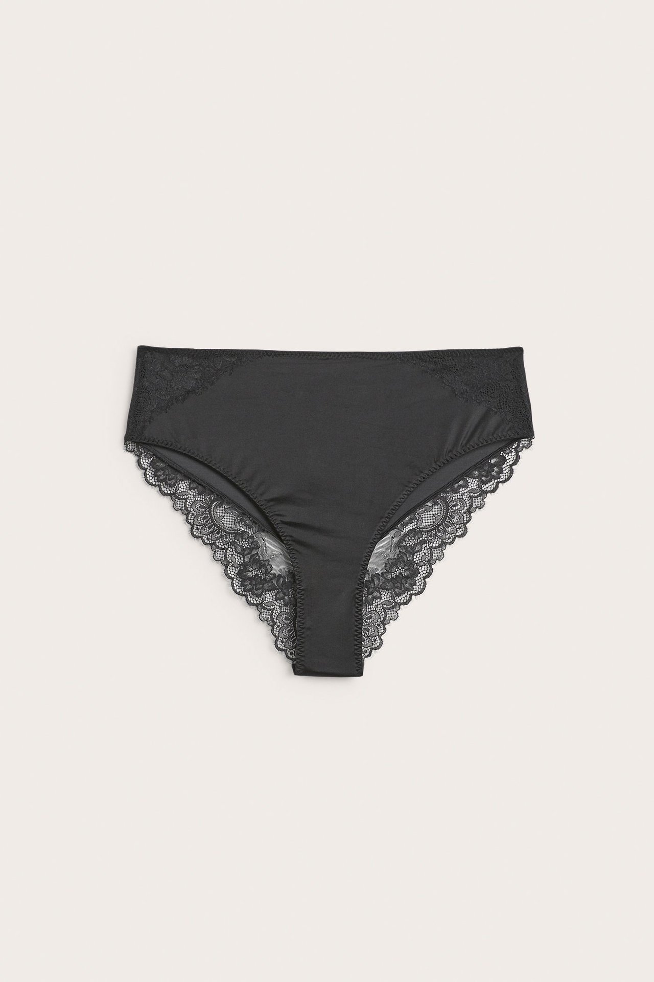 Forfra, svarte sateng micro cheeky truser med blondedetaljer på sidene og benåpningene.