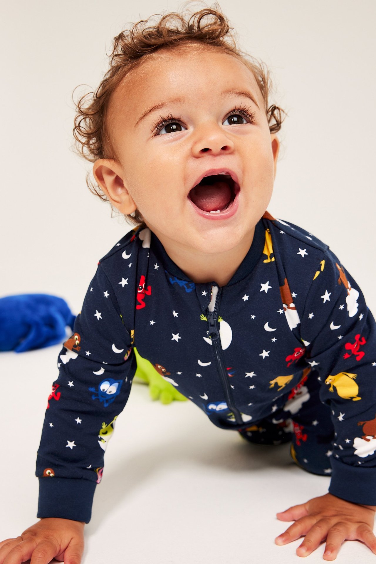 Baby i mörkblå pyjamas med Babblarna motiv, dragkedja fram, mönstrad.