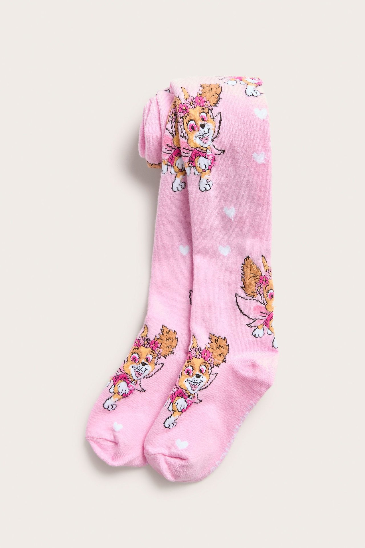 Edestä taitetut vaaleanpunaiset lasten sukkahousut, joissa Ryhmä Hau Skye- ja valkoisia sydänkuvioita.