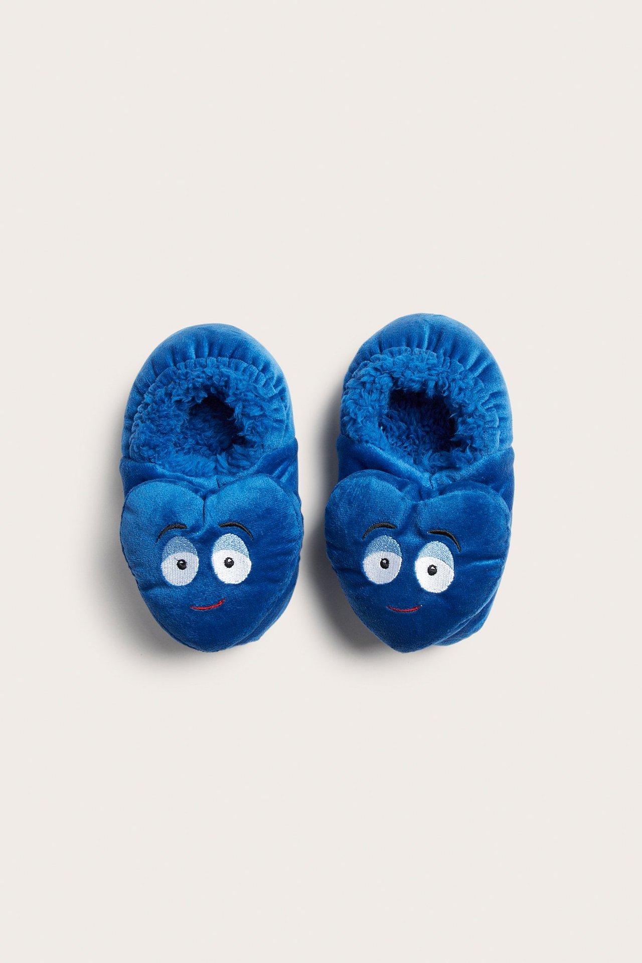 Frontbilde av blå plysjtøfler for baby med broderte ansikter, store øyne og smil.