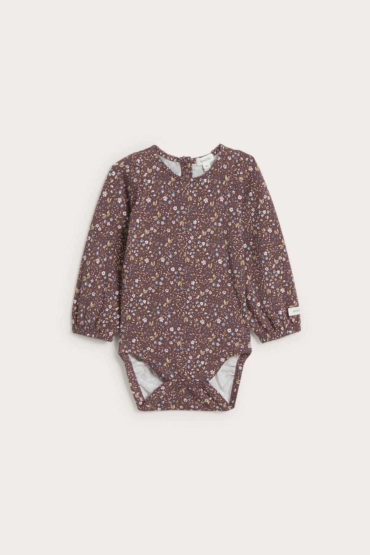 Widok z przodu: ciemnofioletowe body niemowlęce w kwiatowy wzór, z długimi bufiastymi rękawami i wykończeniem picot.