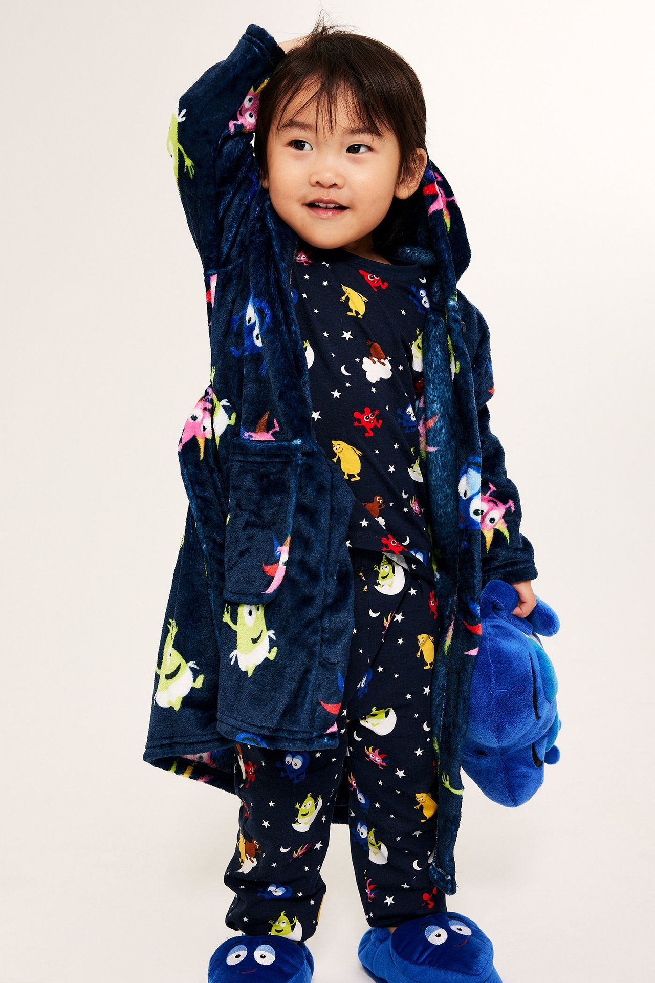 Barn i nattlinnespajd i Mumintrolldesign, blå fleece-rock med cartoonmönster.