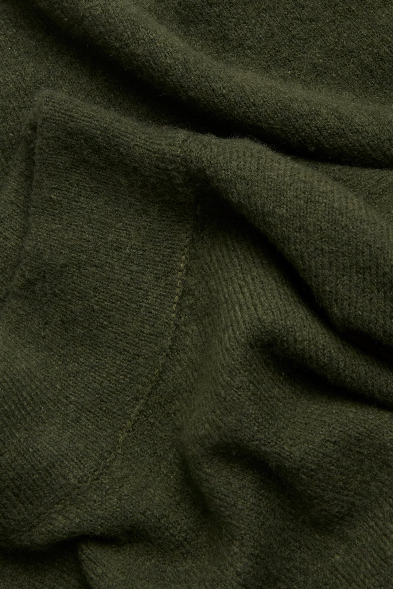 Zbliżenie zielonego, strukturalnego dzianinowego materiału golfu.