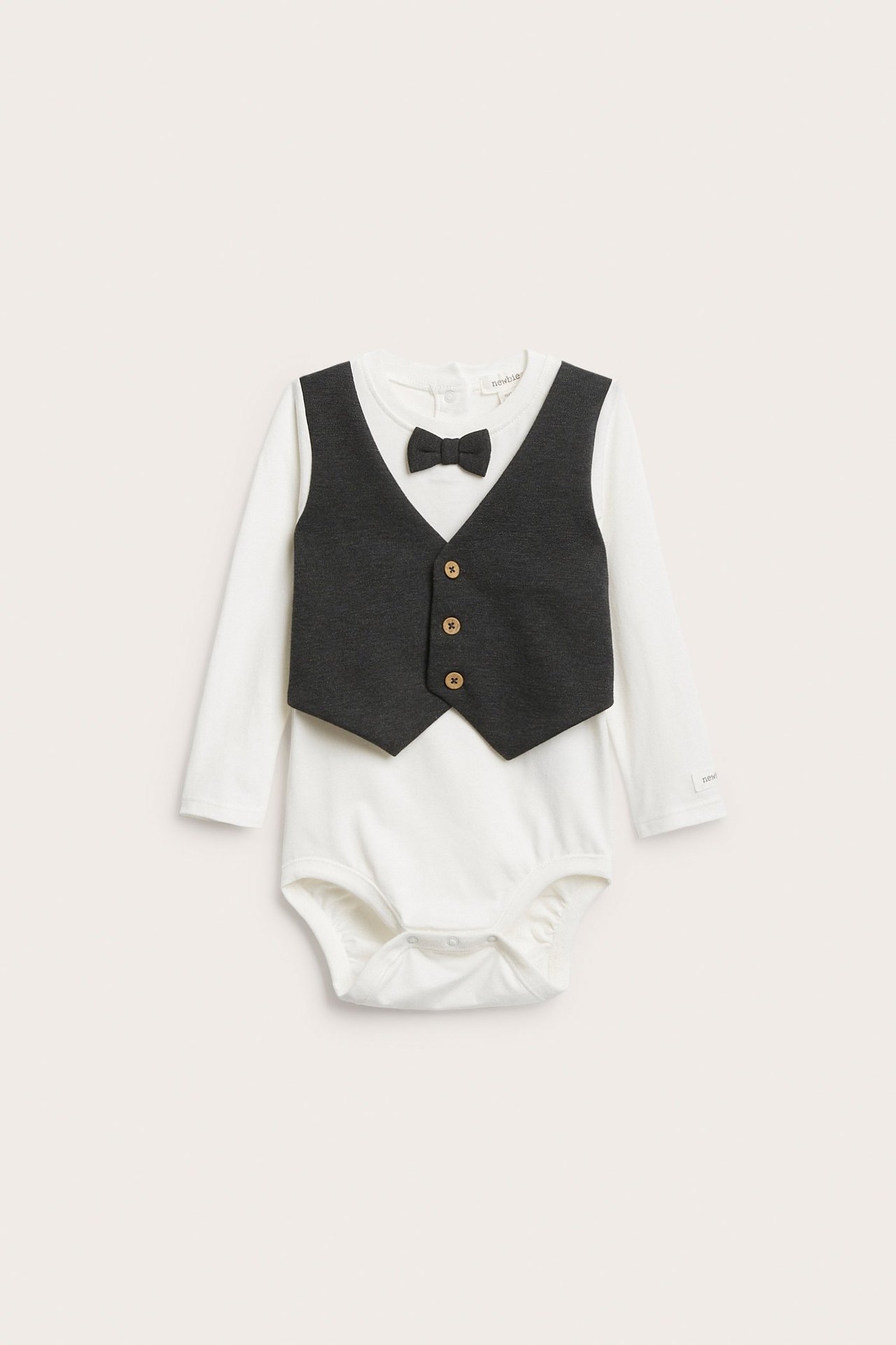 Frontbilde av en offwhite langermet babybody med påsydd mørkegrå vest og sløyfe, med trykknapper.