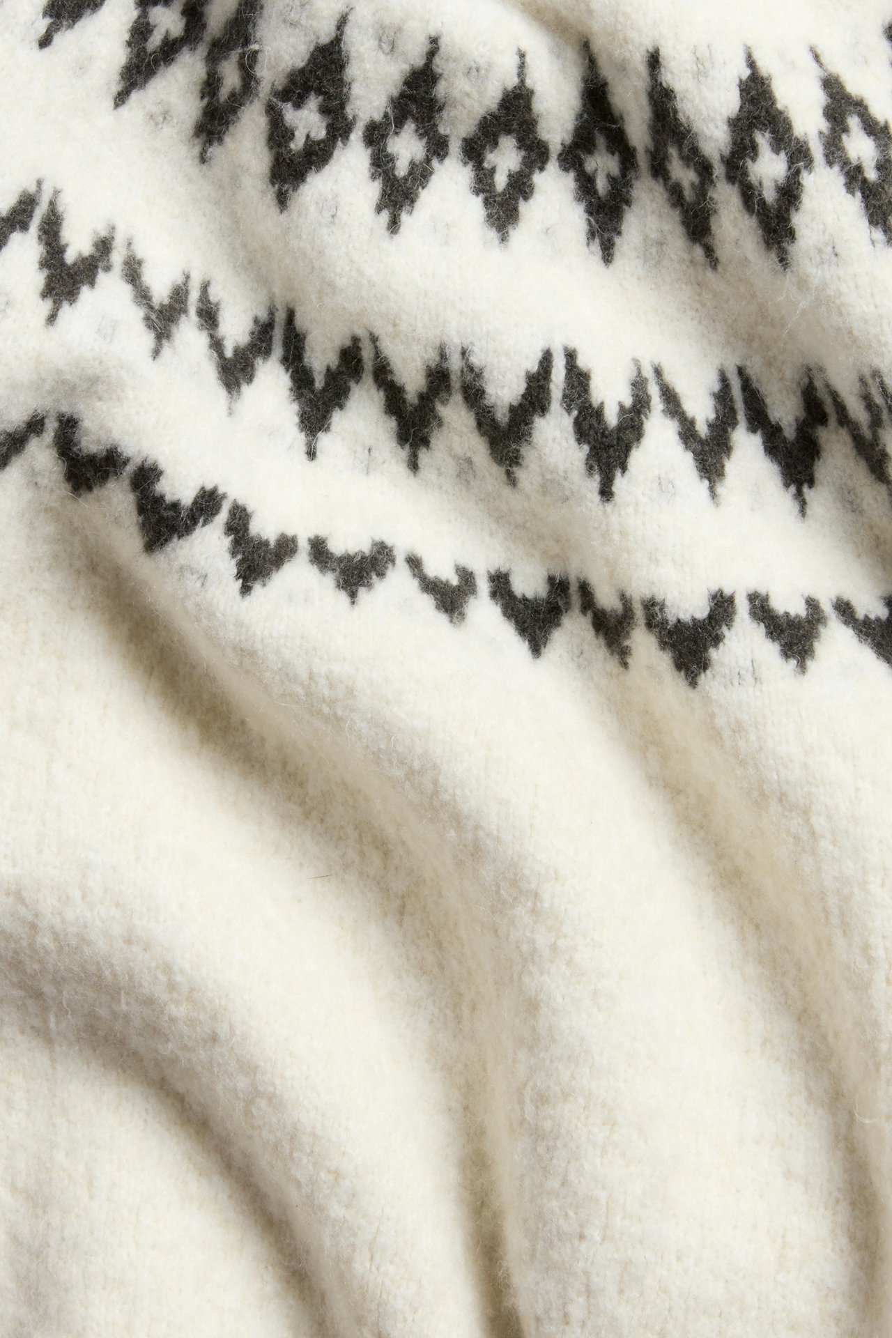 Biała dziewczęca krótka sweter z wzorem Fairisle, z bliska.