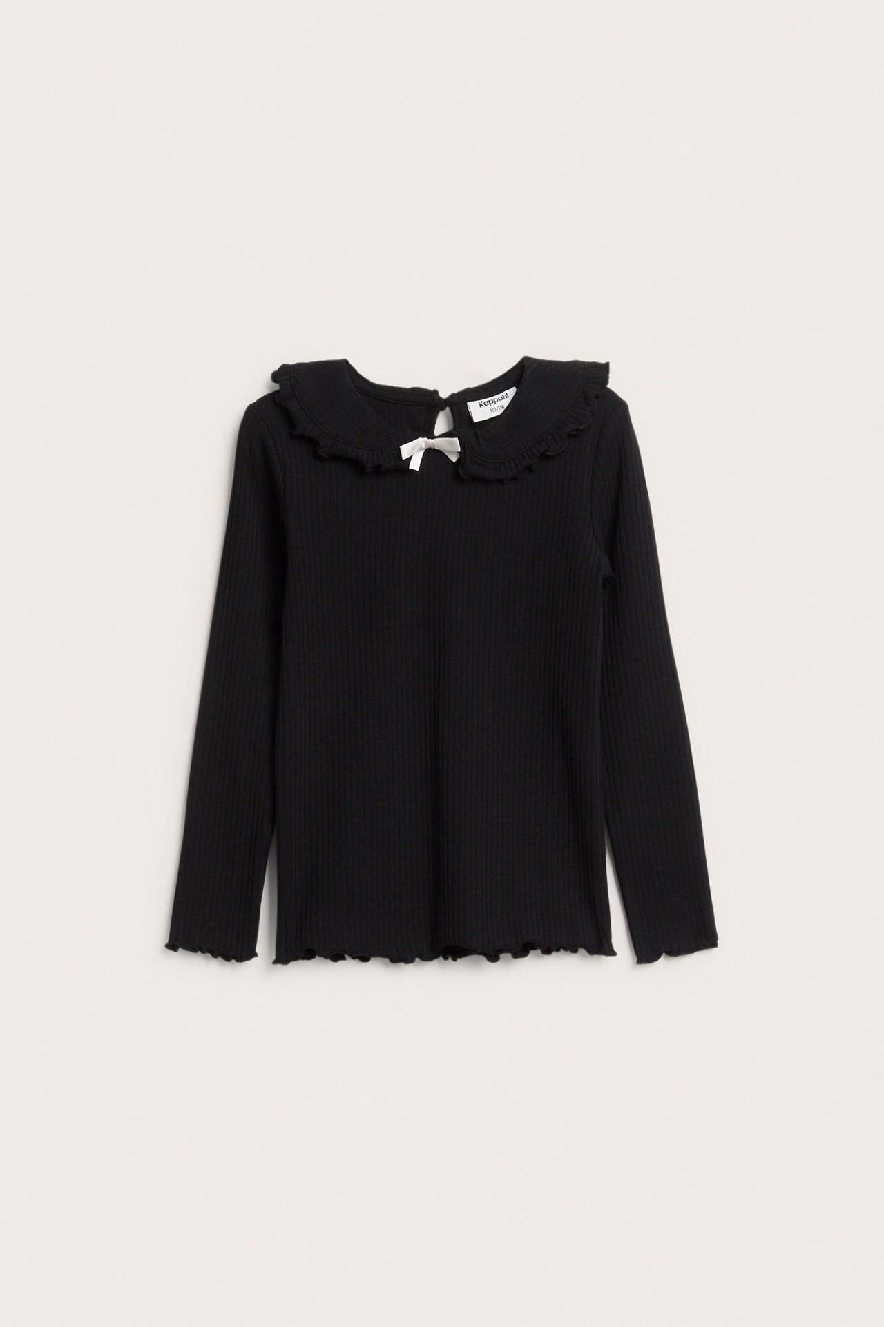 Frontvy av en svart ribbad långärmad topp för barn med volangkrage och en liten vit rosett.