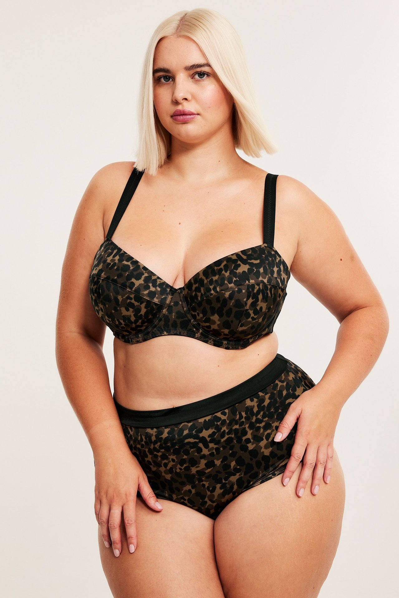 Framsida av kvinna i brun leopardmönstrad vadderad satin-bh och matchande höga trosor.