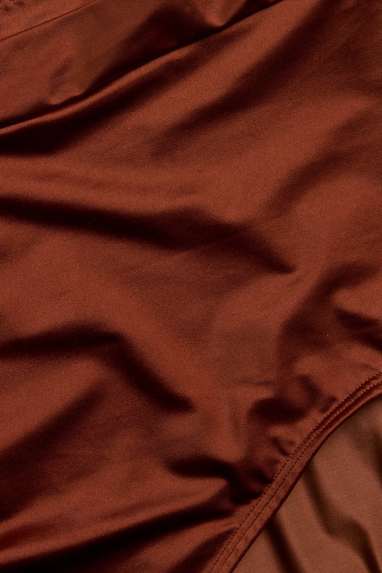 Zbliżenie na rdzawoczerwone, jednolite figi z błyszczącą powierzchnią i widocznym szwem.