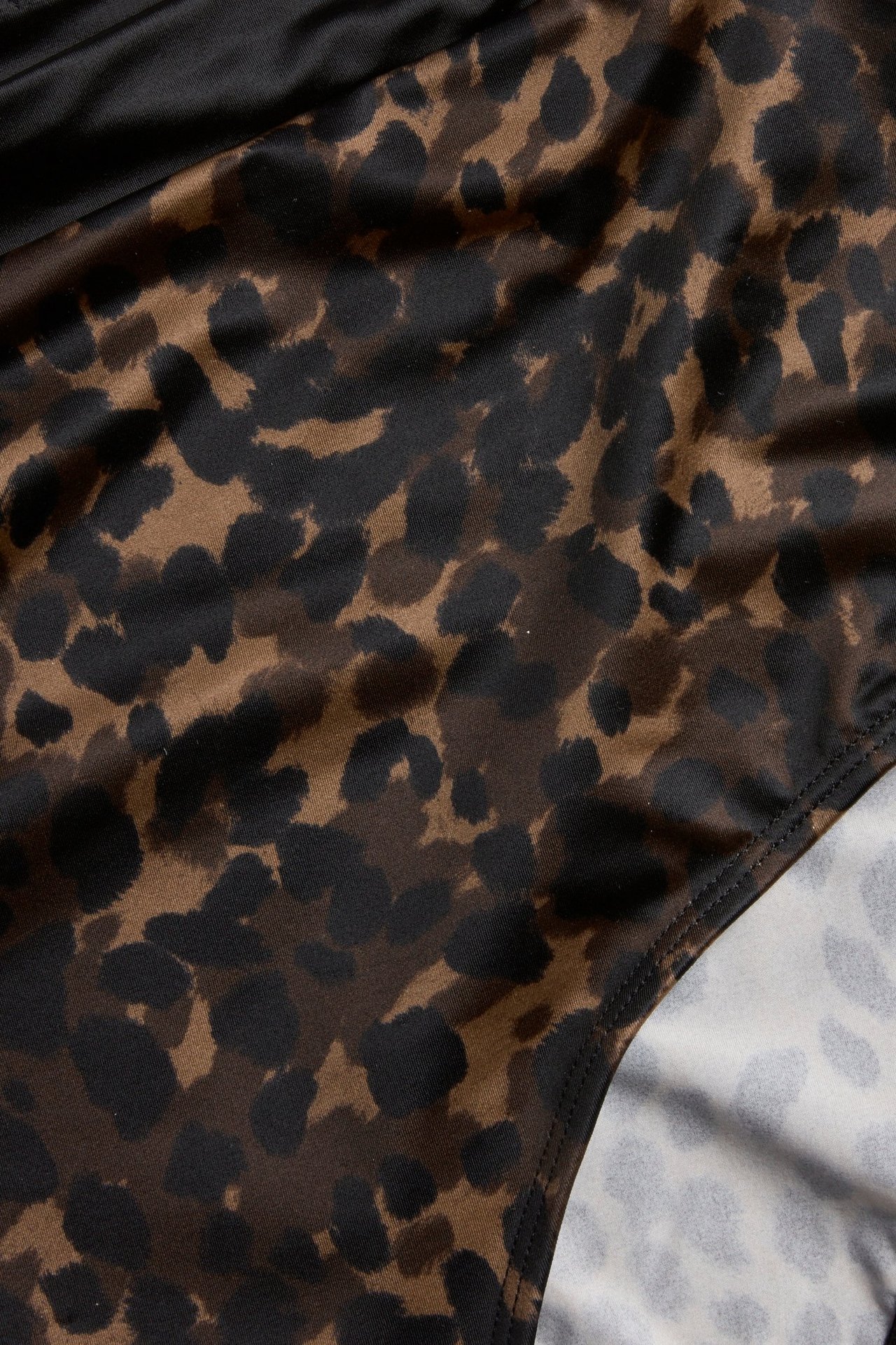 Nærbilde av brun leopardmønstret høy truse med glansfull overflate.