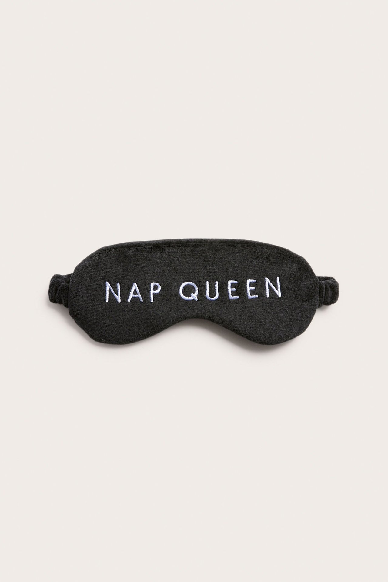 Edestä näkymä mustasta polyesteriunisilmikosta, jossa valkoinen 'NAP QUEEN' -kirjonta ja joustava nauha.