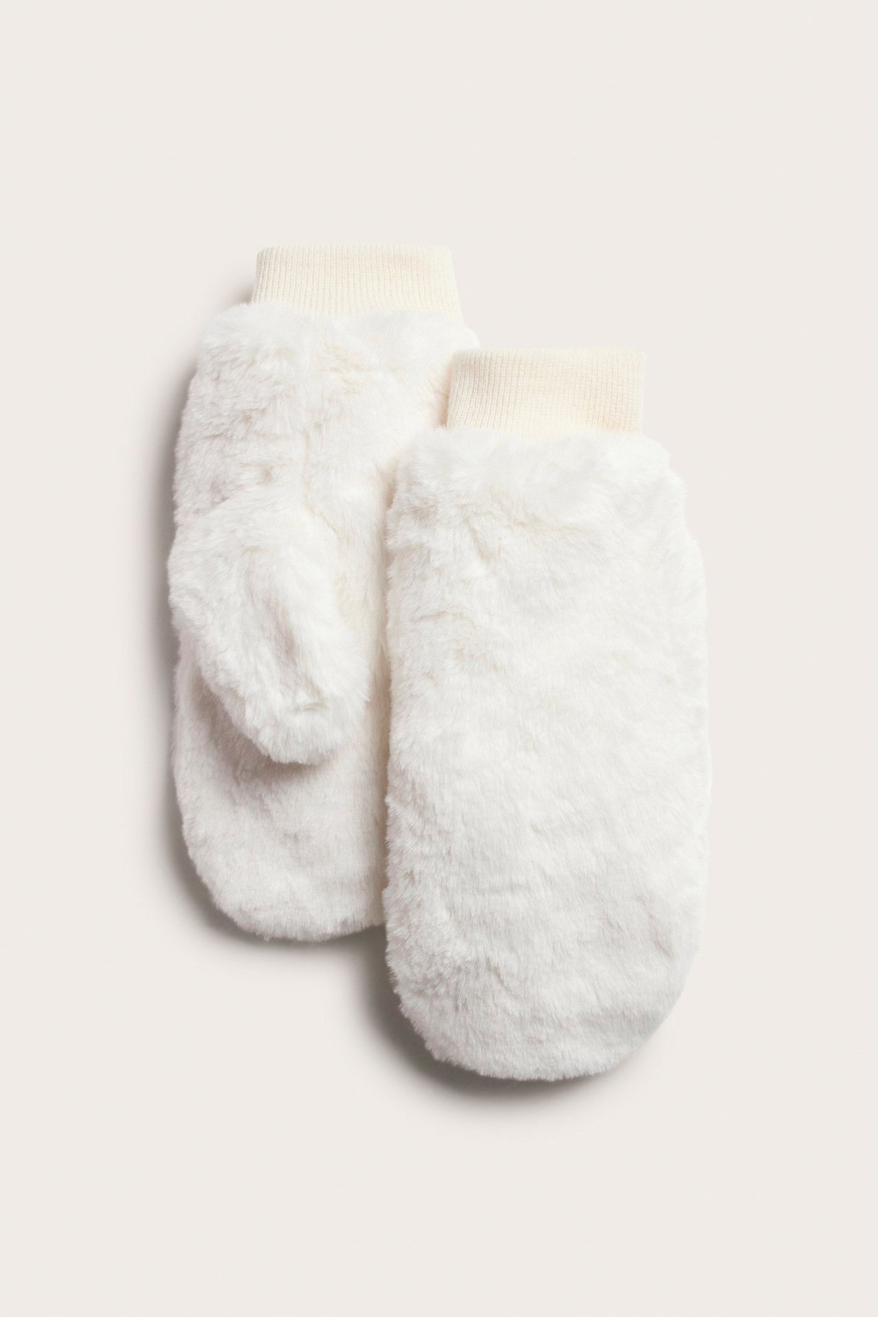 Widok z przodu dwóch ecru futrzanych rękawiczek z prążkowanymi mankietami.