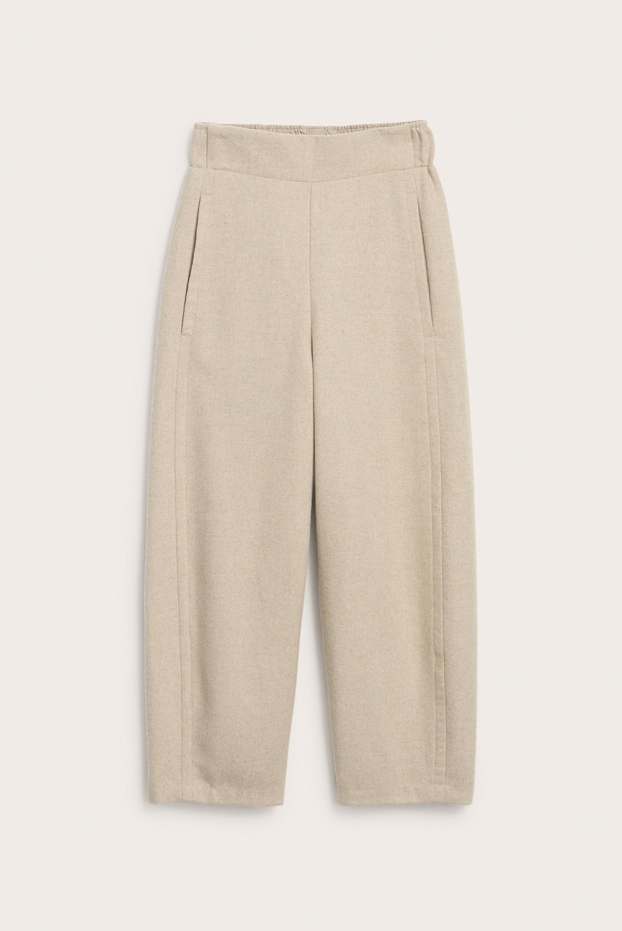 Edestä näkymä beigemelange villasekoite housuista, joissa sivutaskut ja joustava vyötärö takana.