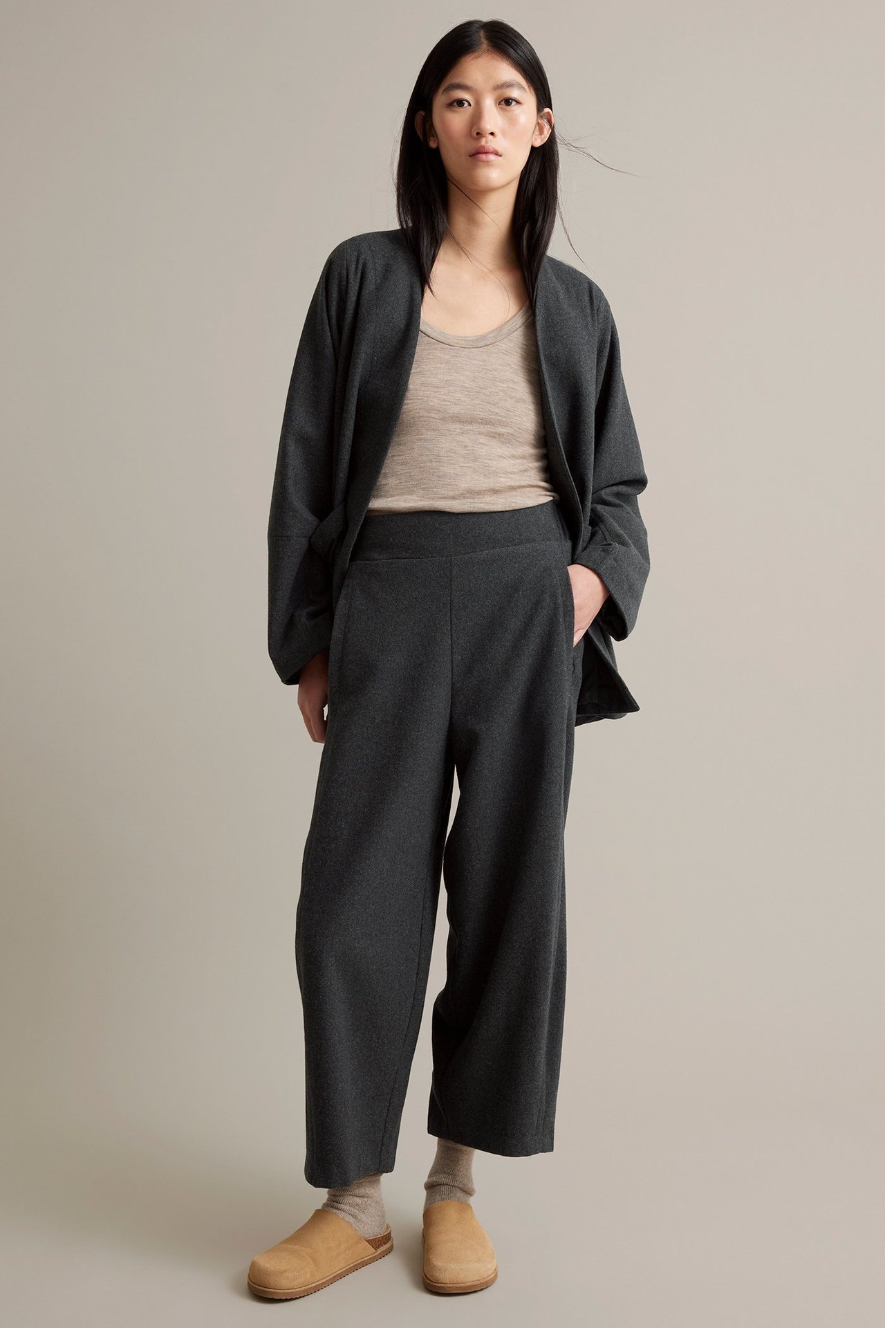 Nainen tummanharmaat villasekoitehousut sivu- ja takitaskuilla, beige tukka.