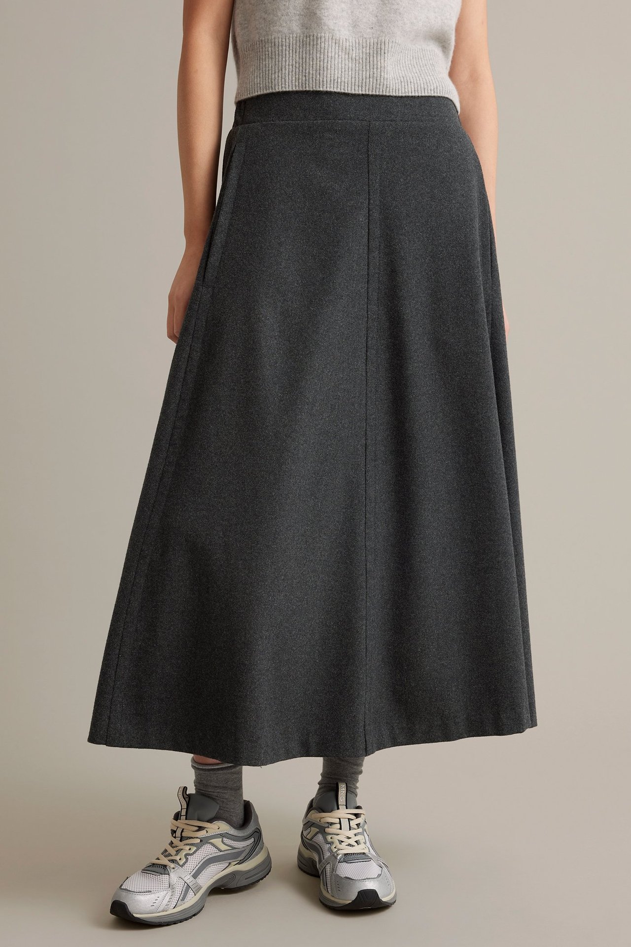 Tummansininen villasekoitekappa, sivutaskut, joustava vyötärö, meleerattu kuosi.