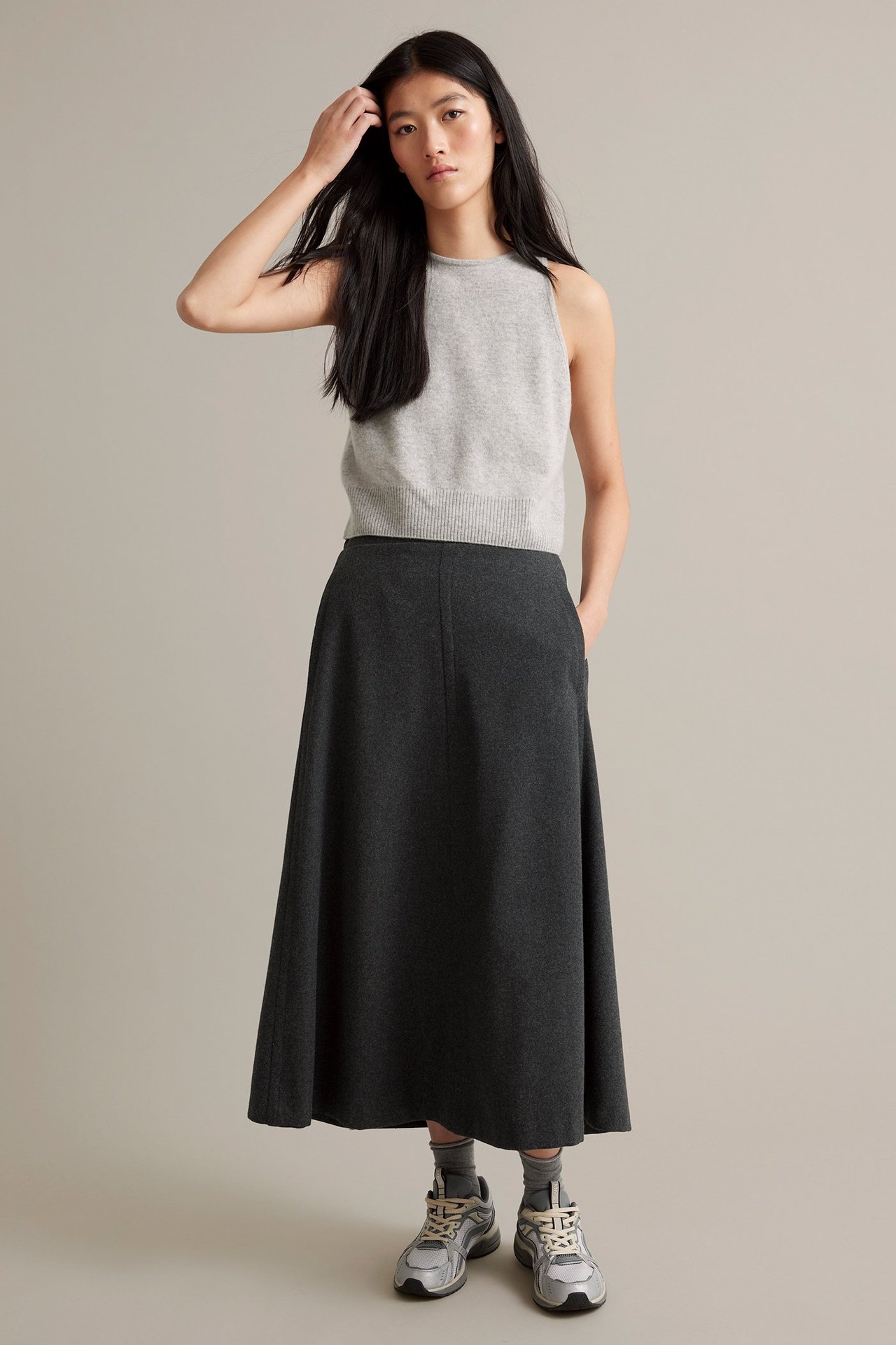 Nainen tummanharmaa mereroitu villasekoitekorke, toppi ja lenkkarit.