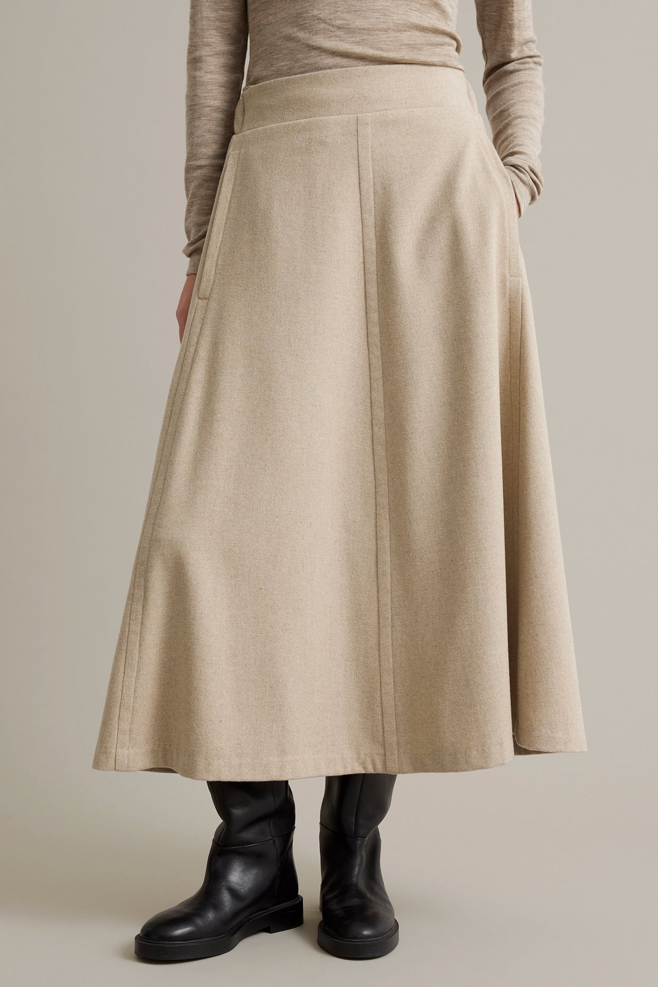 Beige melange-värjätty villasekoituskangas, taskut, elastinen takanauhavyö, takinäkymä.