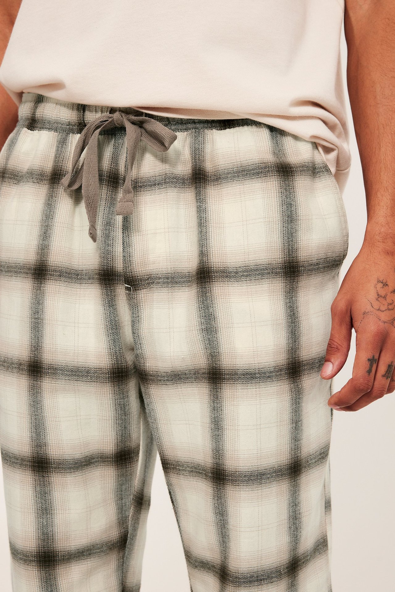 Bruna pyjamasbyxor med rutigt mönster, resår, dragsko i midjan och sidfickor.