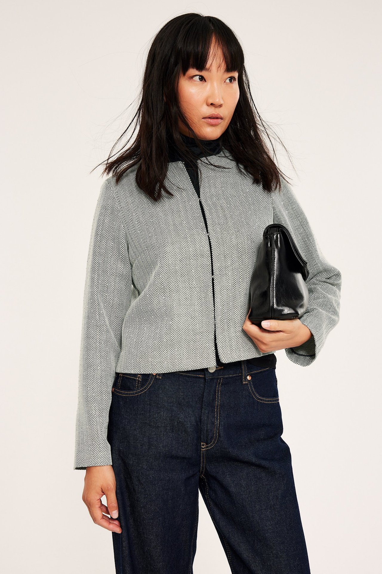 Jasno szara marynarka z kryształkami, błyszczący wzór, zatrzask, kobieta nosi.