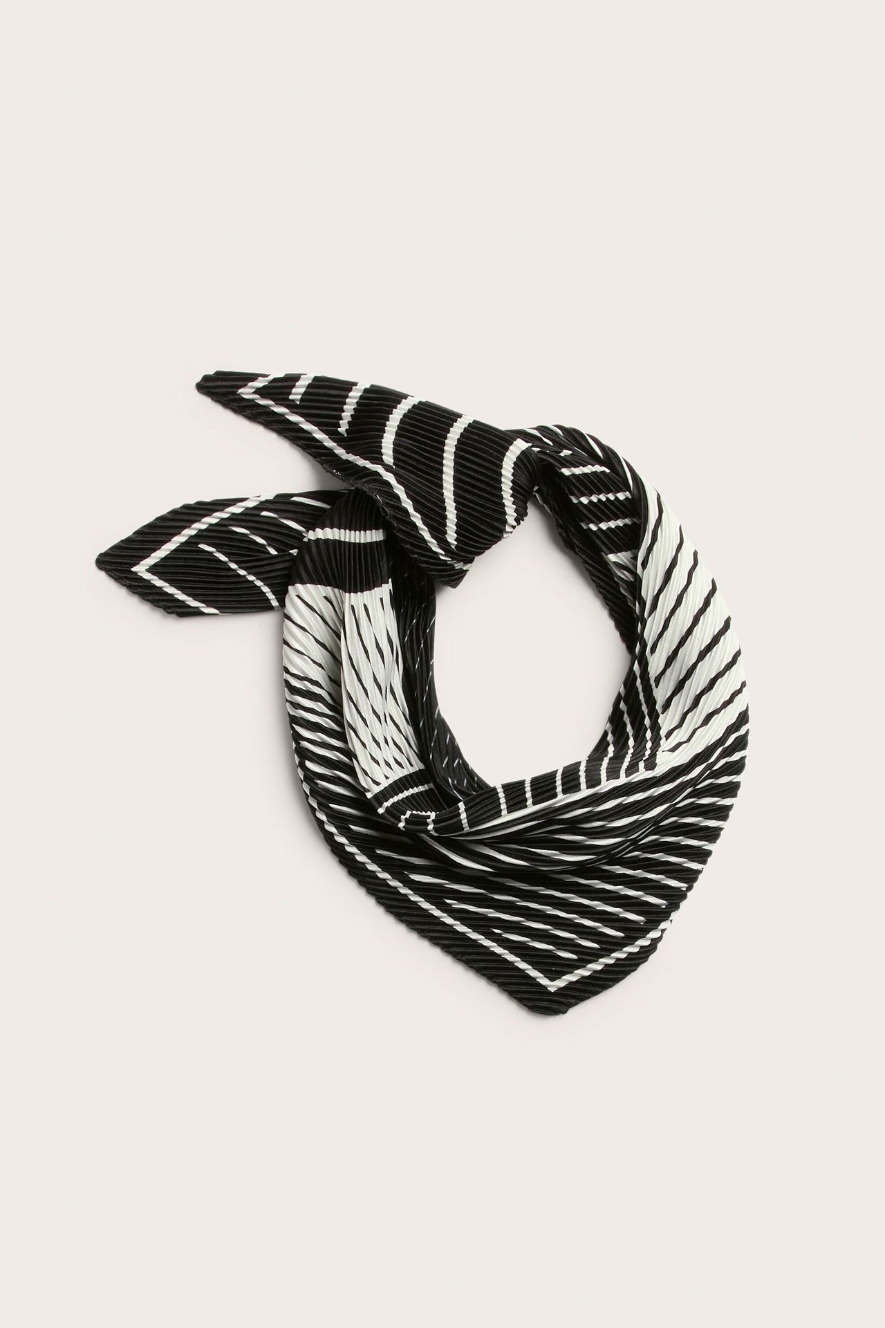 Zbliżenie na czarno-biały wzorzysty, plisowany kwadratowy szalik poliestrowy, złożony.