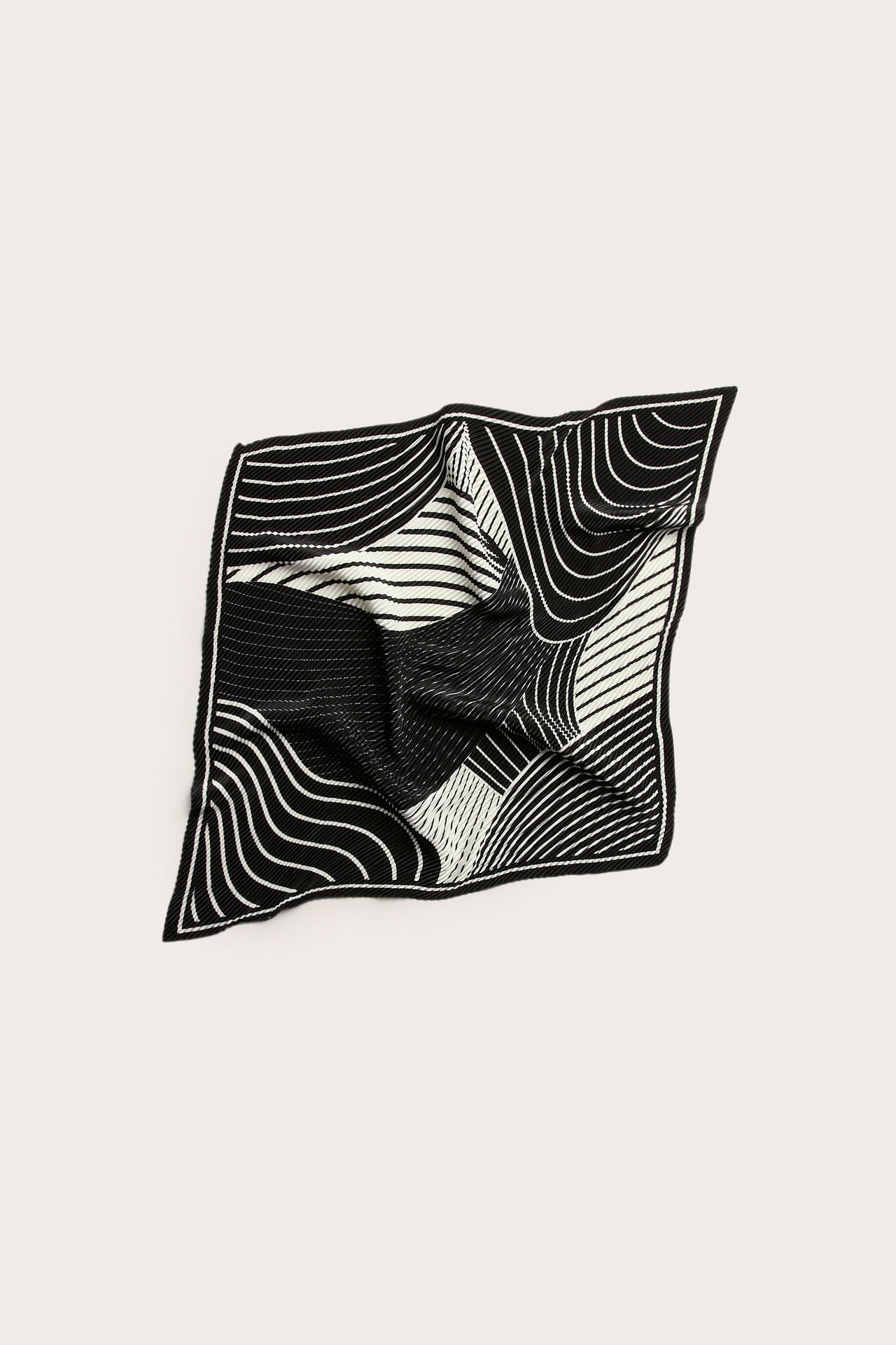 Widok z góry na czarno-biały plisowany kwadratowy szalik poliestrowy z abstrakcyjnym wzorem linii.