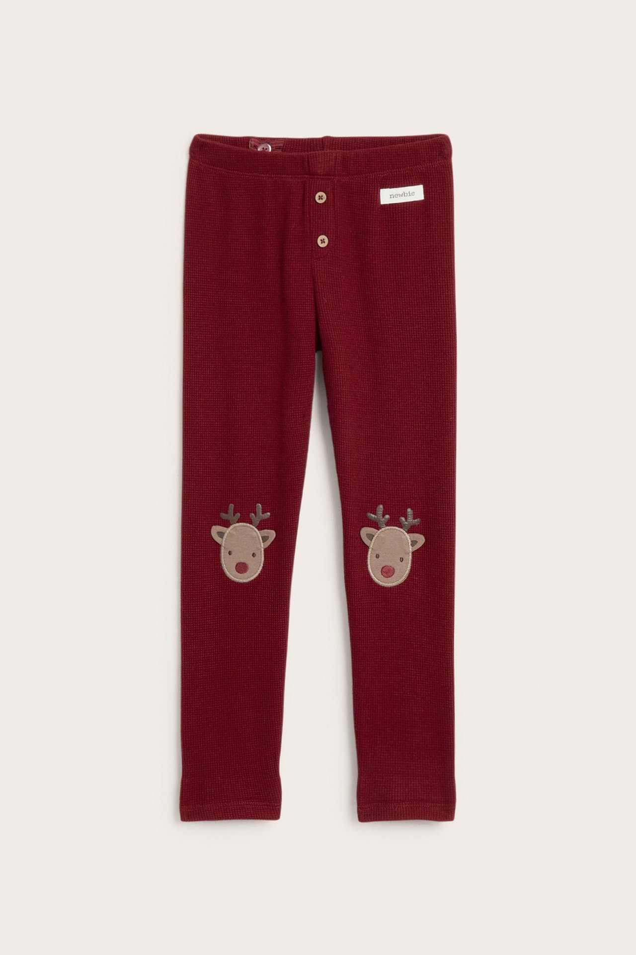 Forfra: Røde vaffelstrikkede leggings for barn med dekorative knapper og reinsdyrapplikasjoner på knærne.