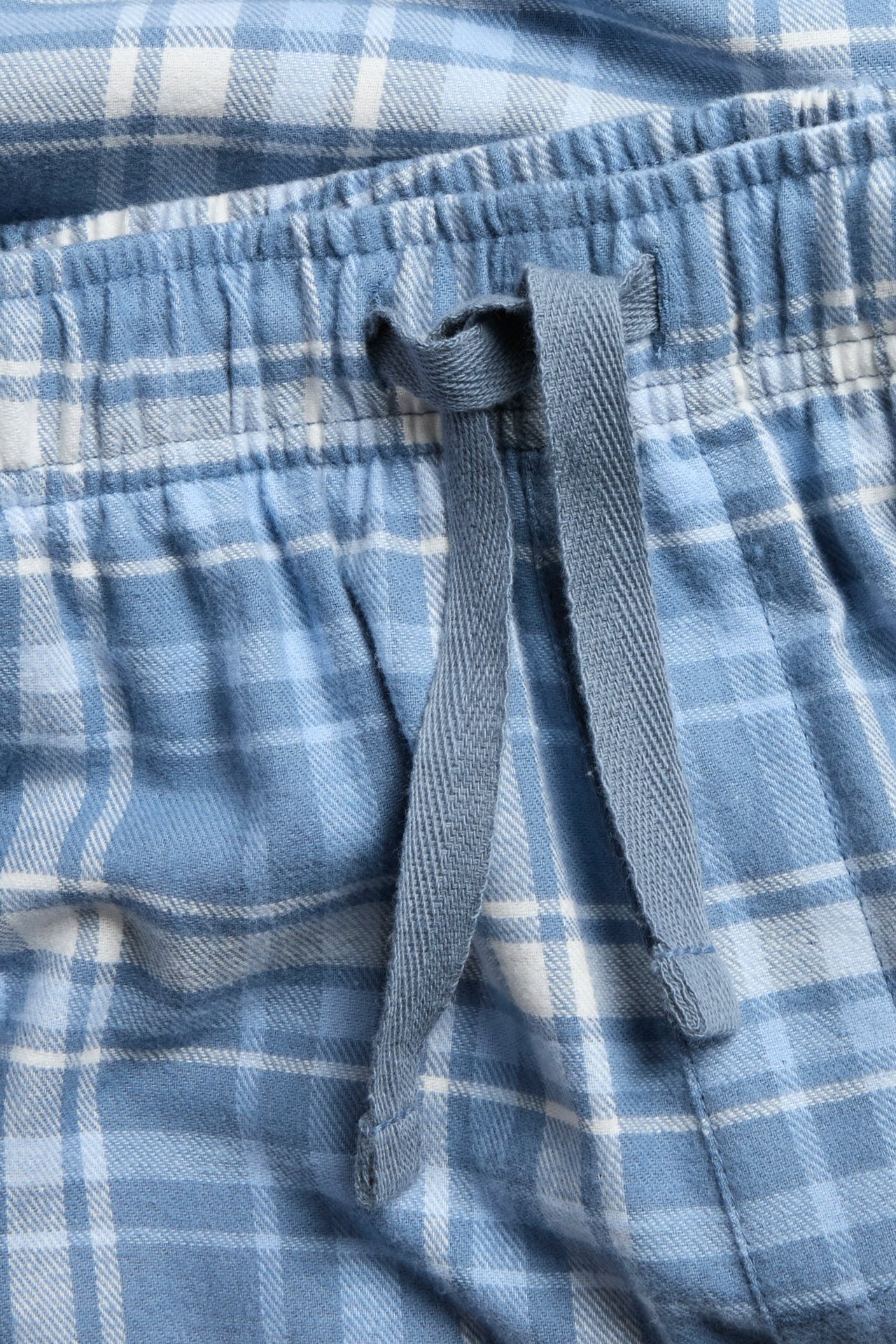 Niebieskie w kratę bawełniane piżamowe spodnie dla dzieci, z elastycznym pasem i sznurkiem, boczne kieszenie.