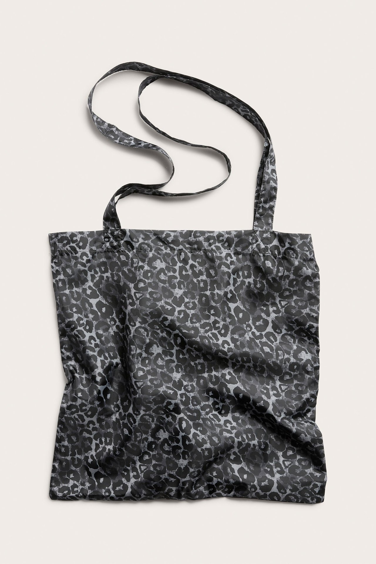 Edestä näkymä harmaasta polyesterisestä ostoskassista, jossa on eläinkuvio ja kaksi kahvaa.