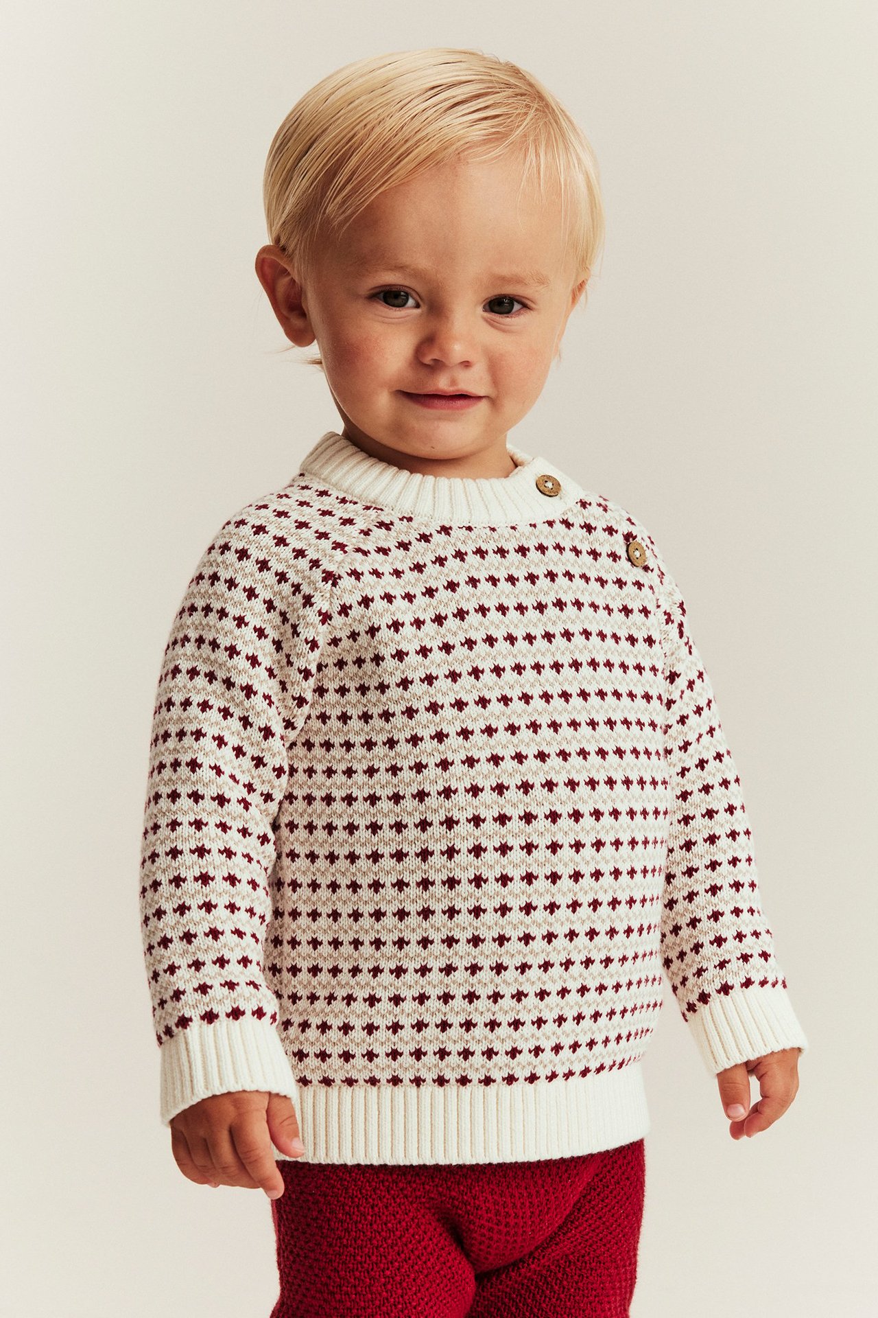 Lapsi offwhite-värinen makea neulottu villapaita neppareilla, raglan-hihat, ribbit, jacquard-kuvio.