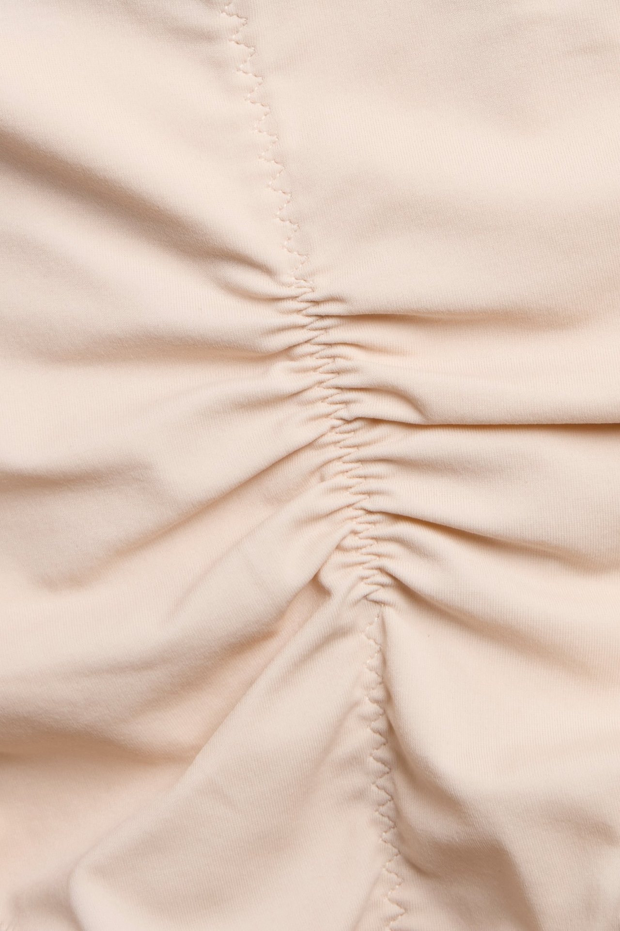 Zbliżenie na jasnoróżowe, jednolite figi modelujące typu hipster z marszczonym detalem.