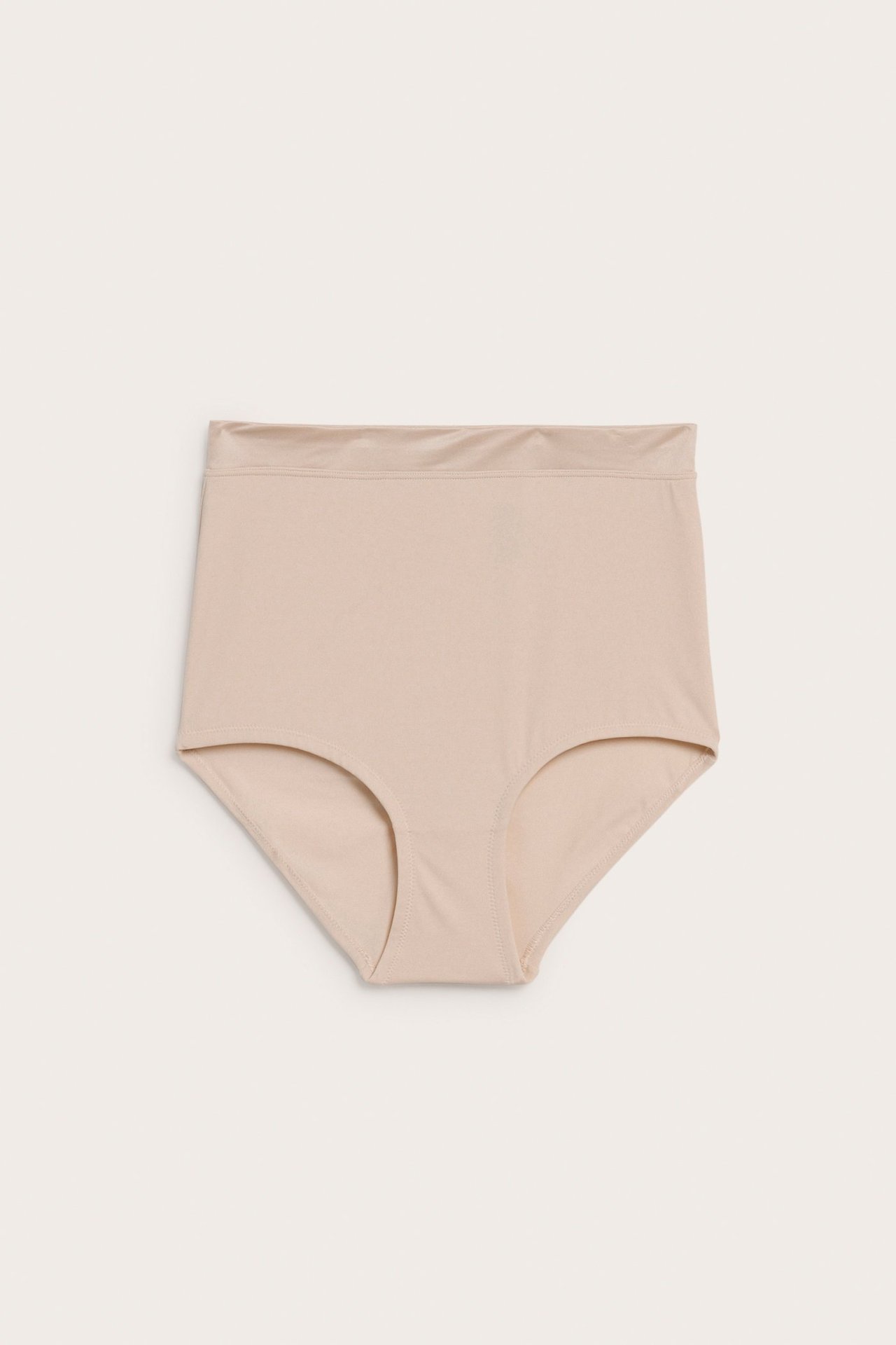 Frontvy av beiga, högmidjade shaping hipstertrosor för dam i slätt, enfärgat tyg.