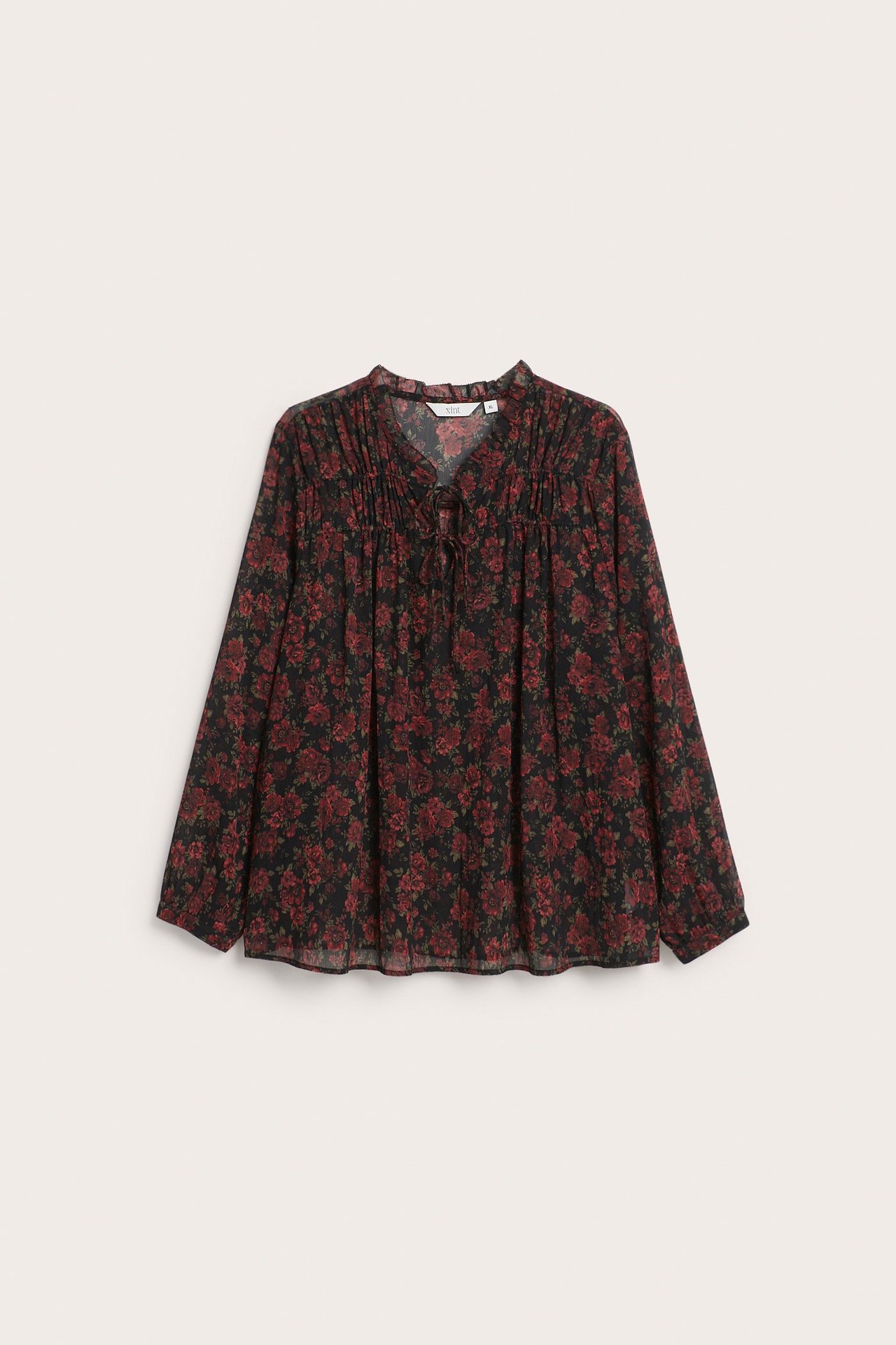 Widok z przodu: Czarna, długa bluzka we wzory, z czerwonymi kwiatami, dekoltem V i troczkiem.