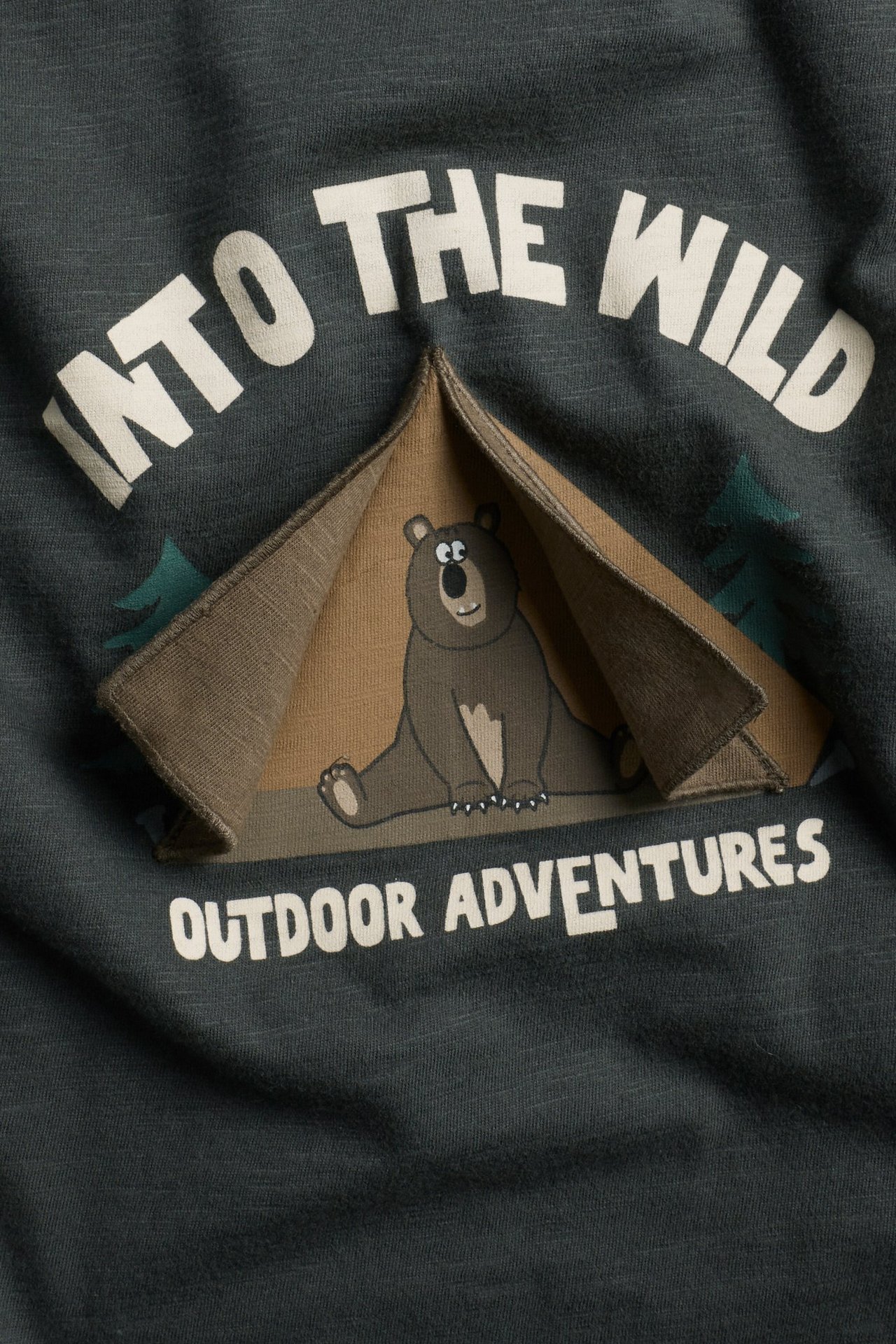 Nærbilde av en mørkegrå langermet T-skjorte i bomull med trykk av et åpningsbart telt og bjørn.