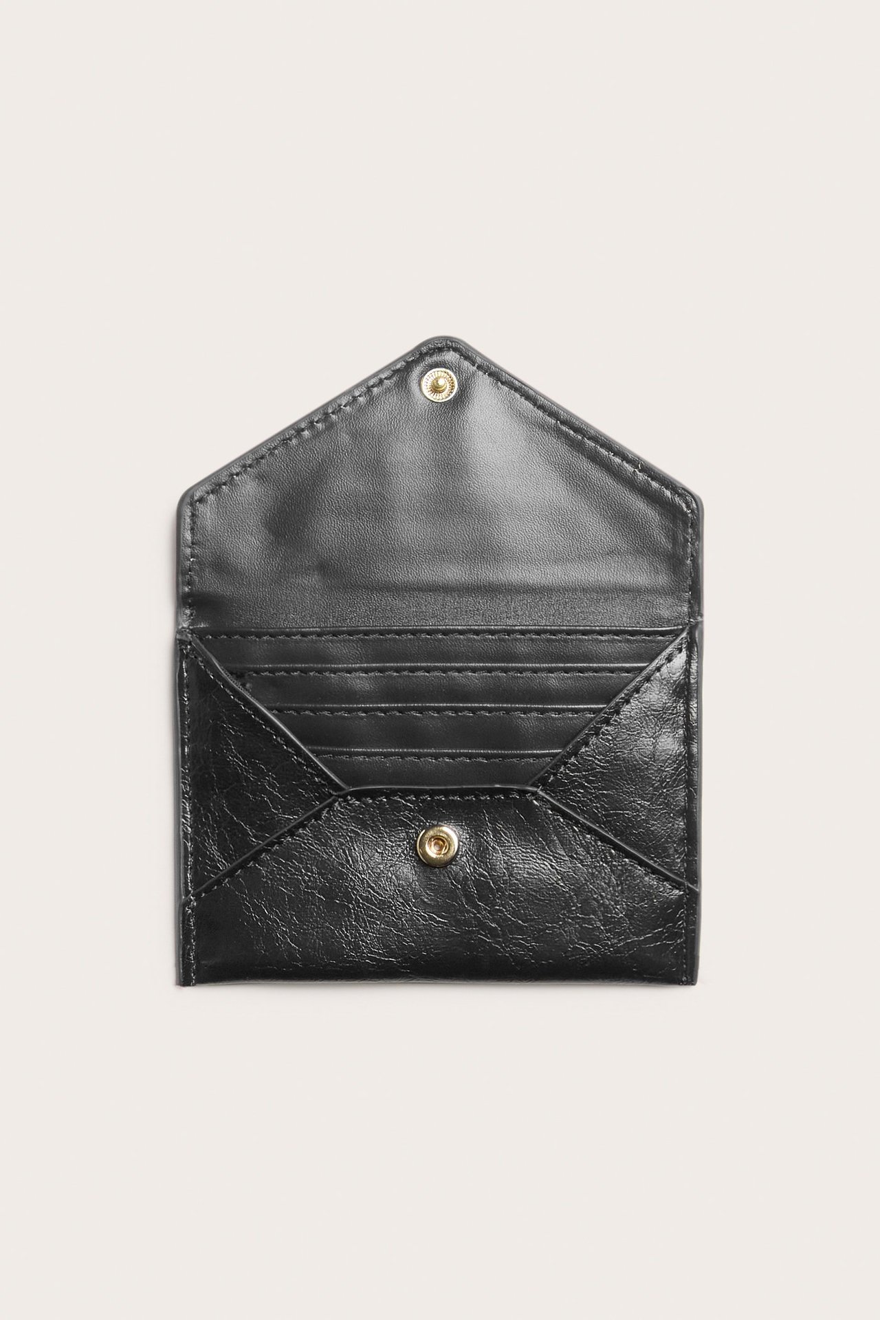 Ovanifrånvy av en öppen svart korthållare i skinnimitation med guldfärgad tryckknapp och kortfack.