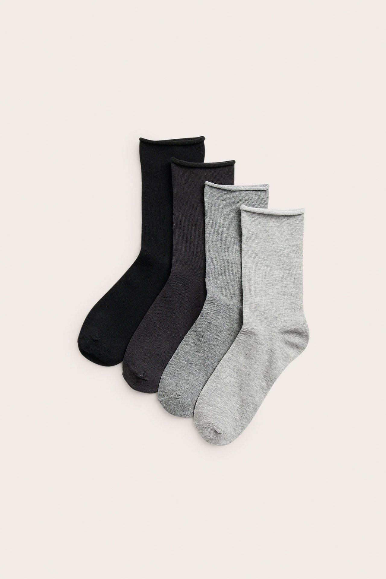 Widok z góry czterech par bawełnianych skarpet w odcieniach szarości i czerni, z rolowanymi brzegami.