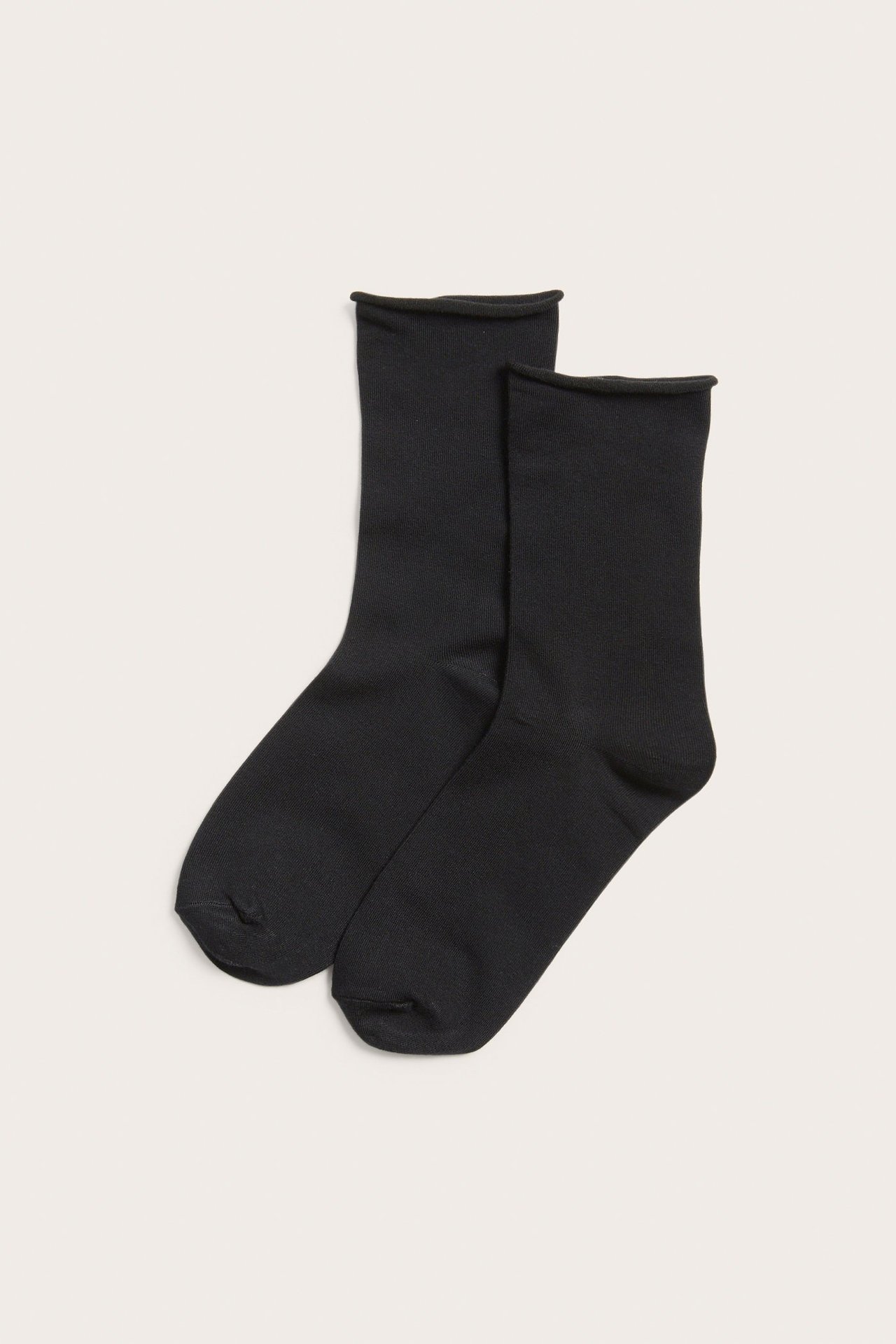 Ylhäältä kuvattuna, kaksi yksiväristä mustaa sukkaa rullatuilla reunoilla, puuvillasekoitetta.