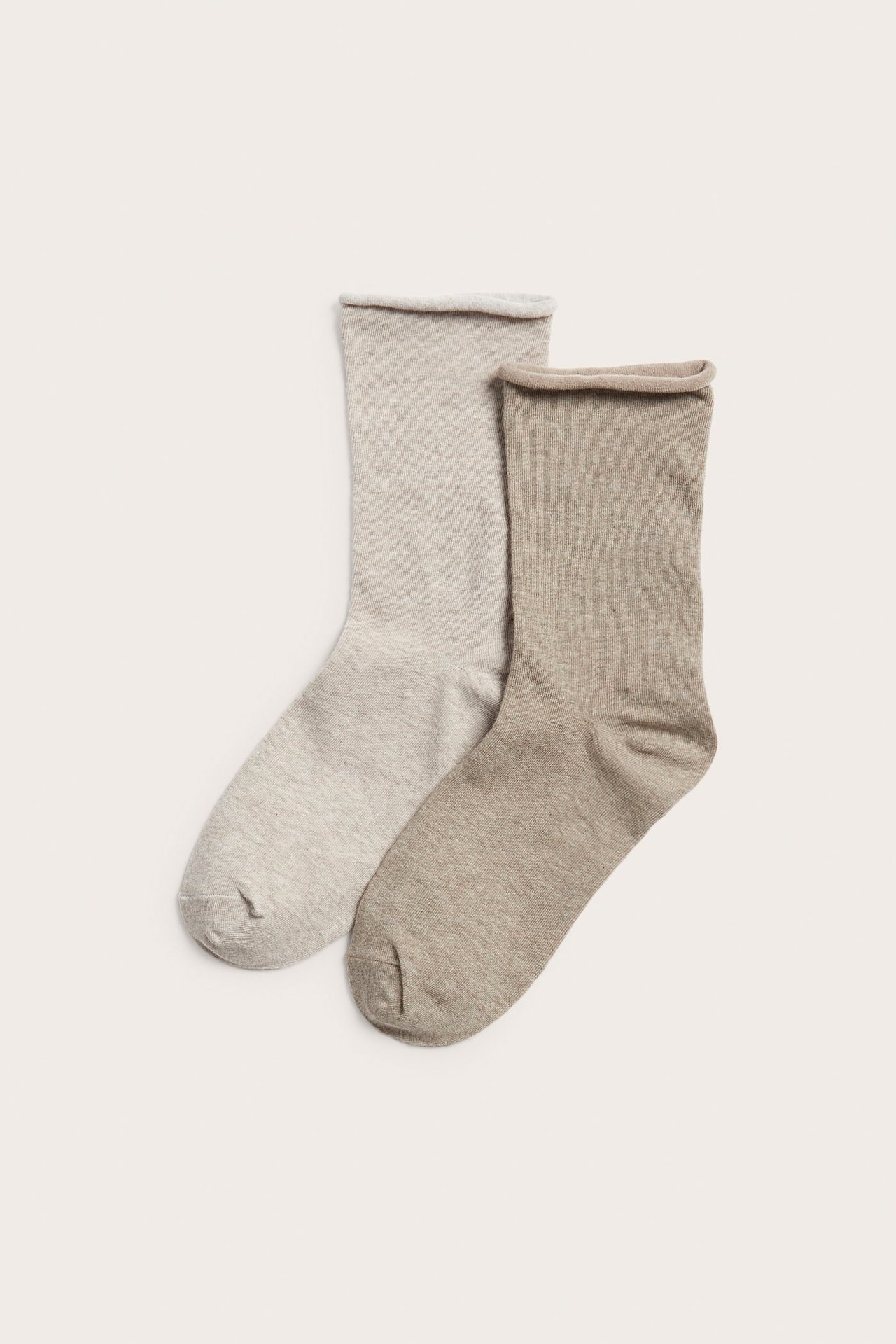 Ovenfra sett, to par melert beige sokker med rullekanter.