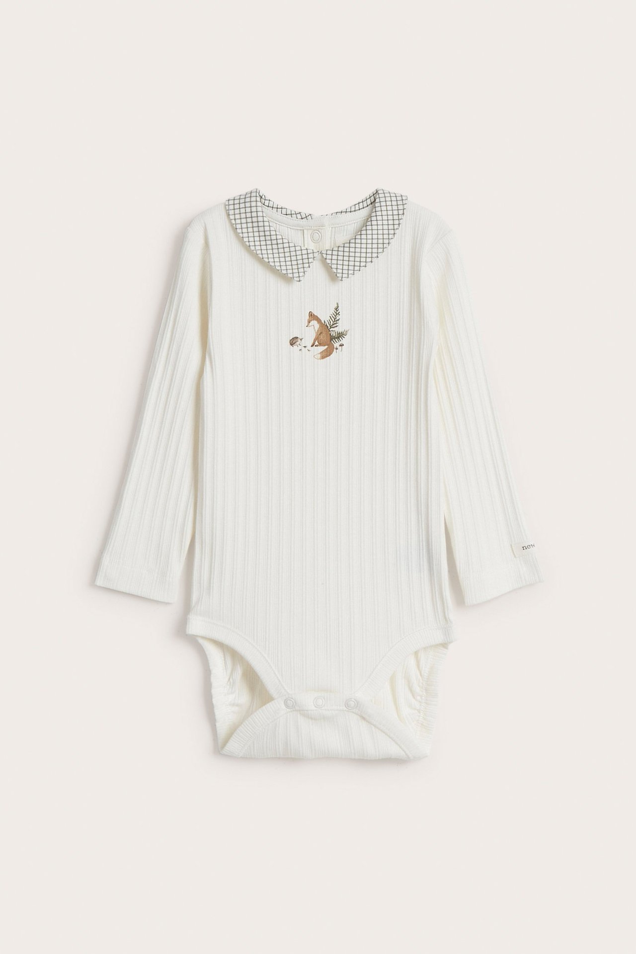 Edestä näkymä luonnonvalkoisesta ribatusta vauvan body-paidasta, jossa ruudullinen kaulus ja kettupainatus.