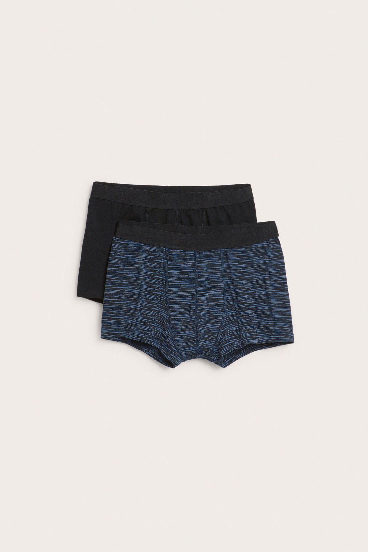 Widok z przodu: dwie pary bokserek dziecięcych, jedne niebiesko-czarne melanżowe, drugie czarne, z gumką w pasie.