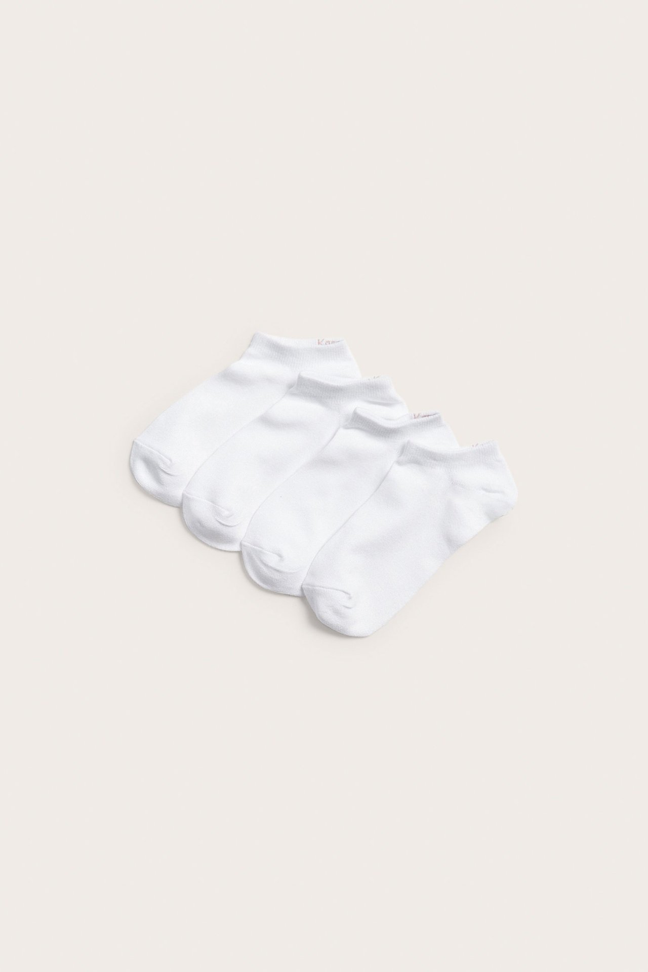 Widok z góry na cztery pary białych, jednokolorowych skarpetek typu sneakers z mieszanki bawełny.