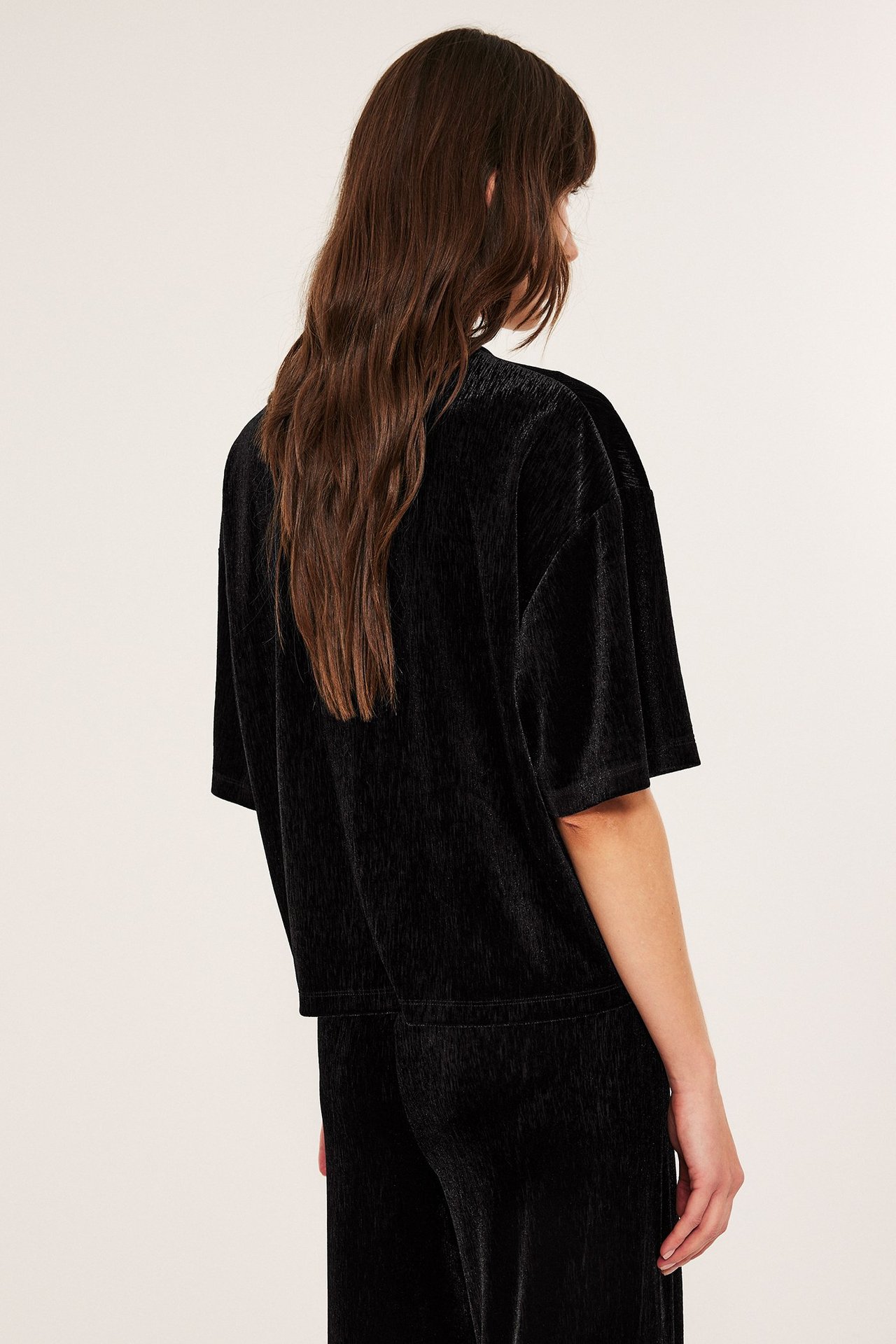 Svart løs passform velour-topp for kvinne, kort erme, ensfarget, bakfra visad.